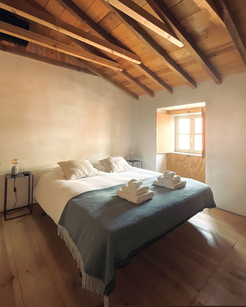 chambre minimaliste avec poutres appartement rénové Portugal