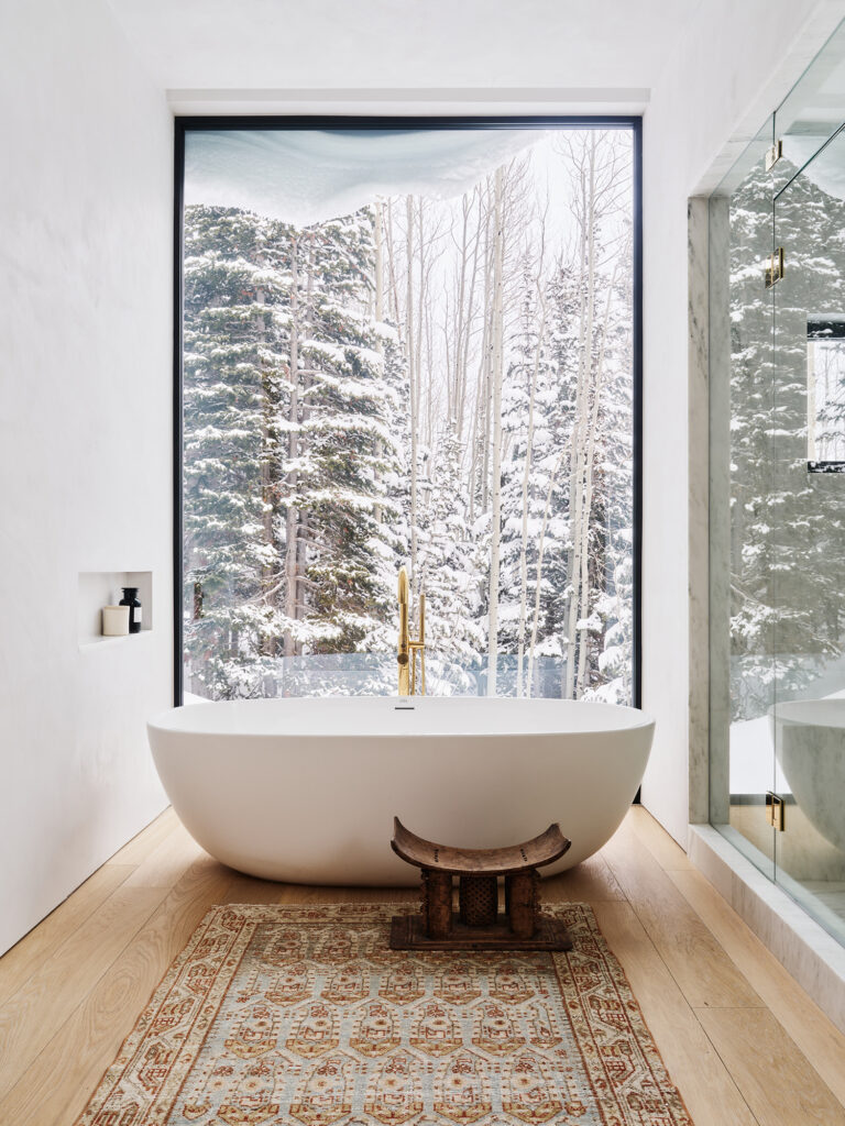 salle de bain baignoire îlot décoration design grandes baies vitrées paysage neigeux de montagne