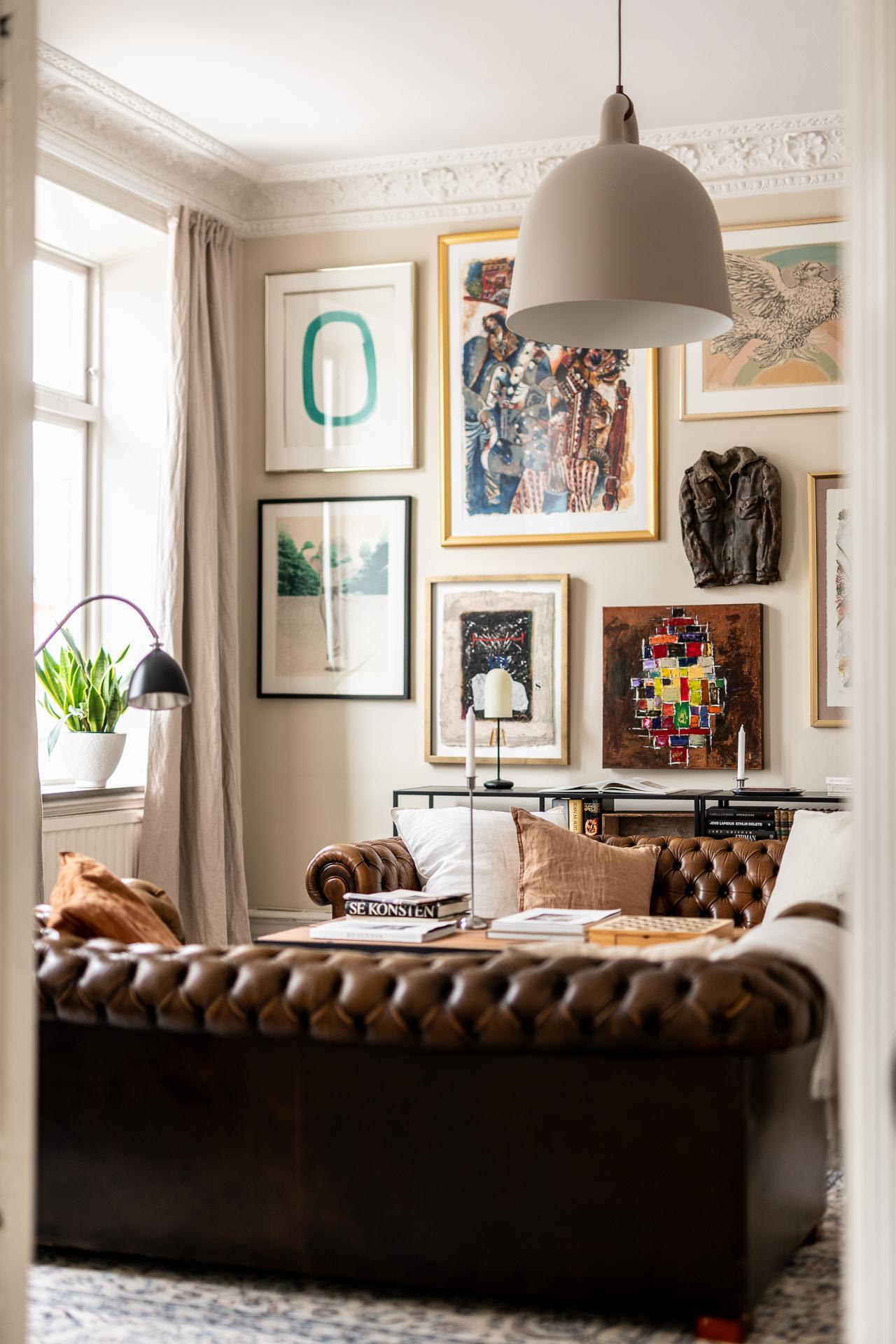 salon avec canapé Chesterfield cuir marron moulures appartement type haussmannien décoration classique chic