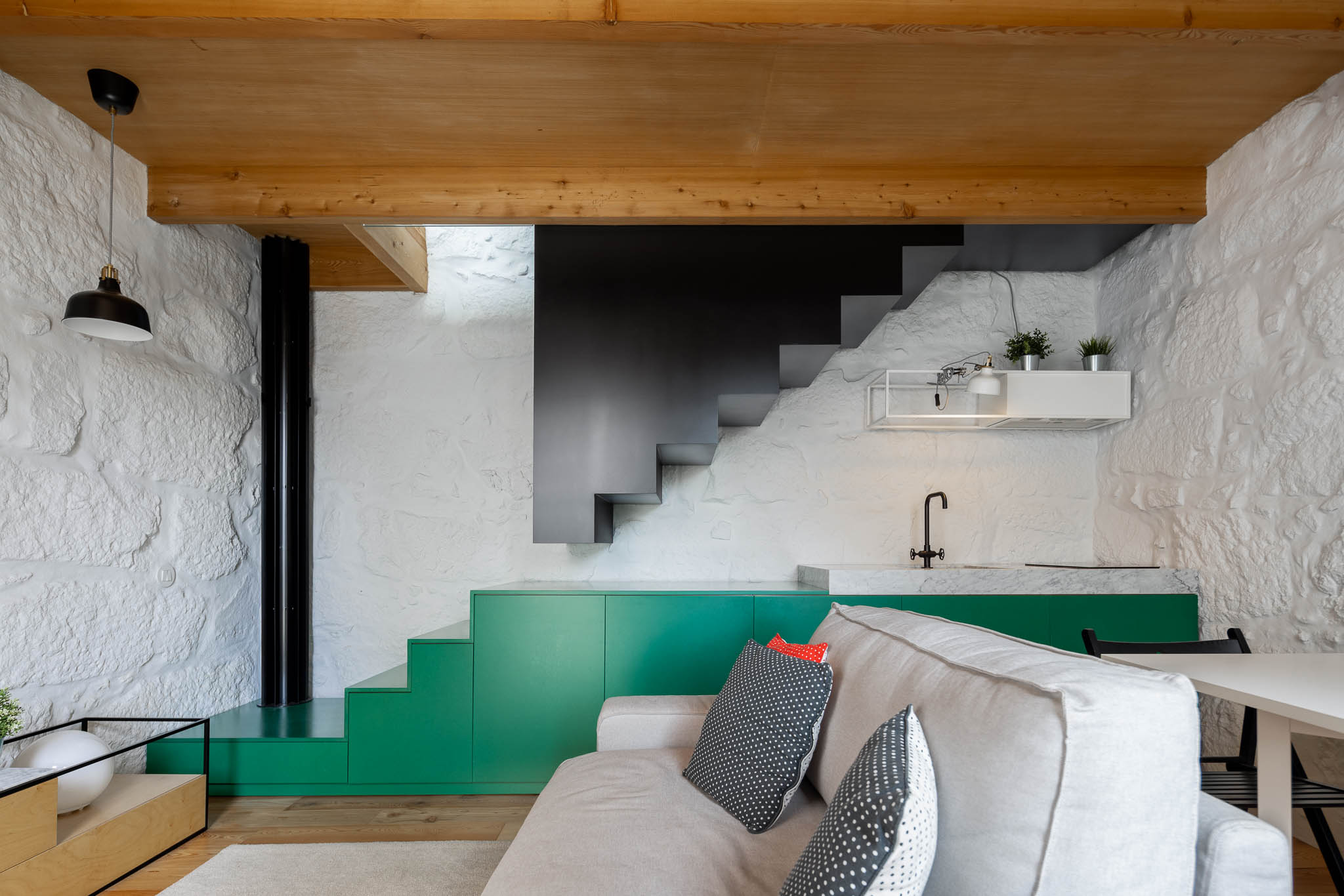 salon murs anciens décoration design avec escalier et cuisine verte studio 32m2 Portugal