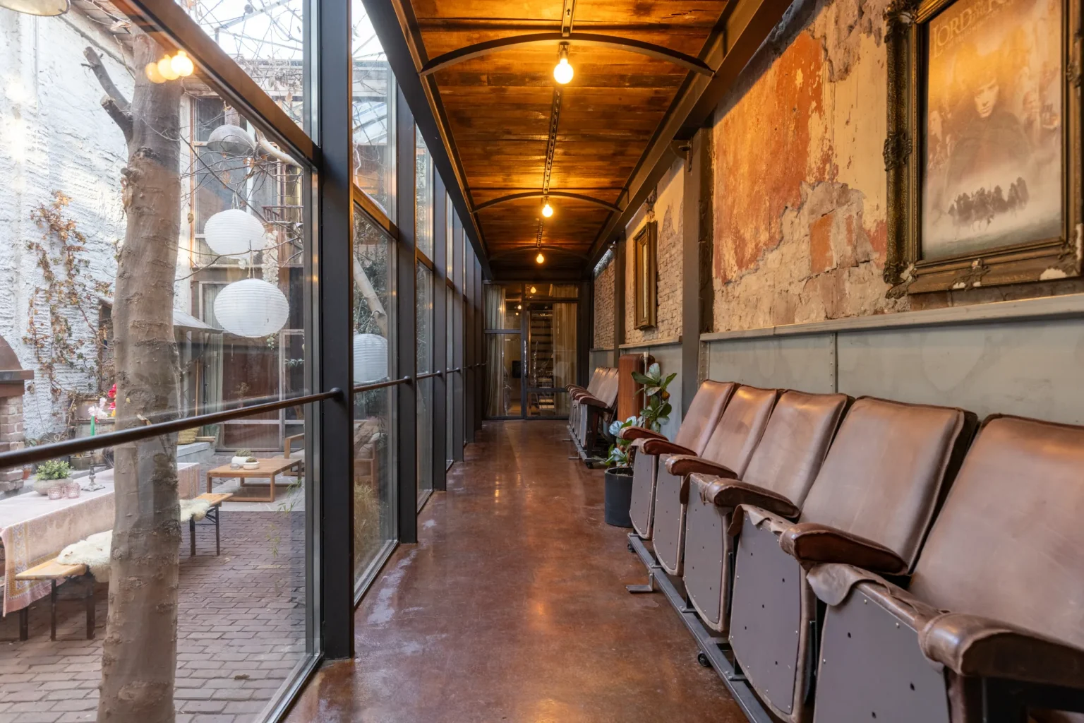 couloir avec fauteuils ancien cinéma dans maison de ville avec cour