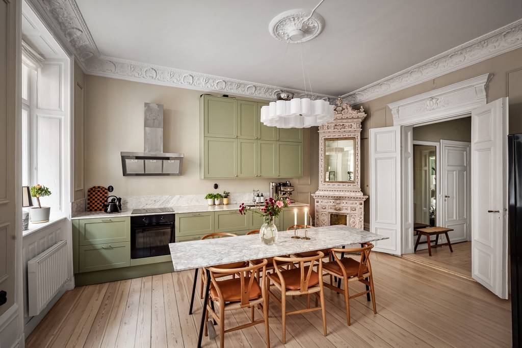 cuisine vert sauge avec moulures stucs rosaces et poêle ancien appartement décoration scandinave