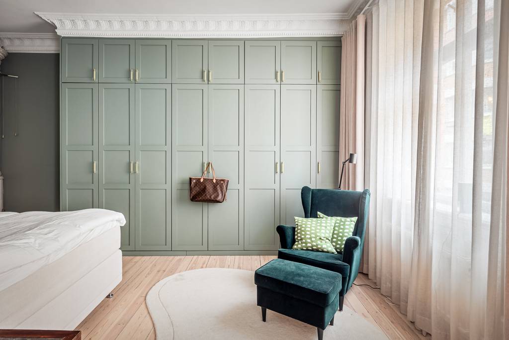 chambre vert sauge avec moulures stucs rosaces et poêle ancien appartement décoration scandinave