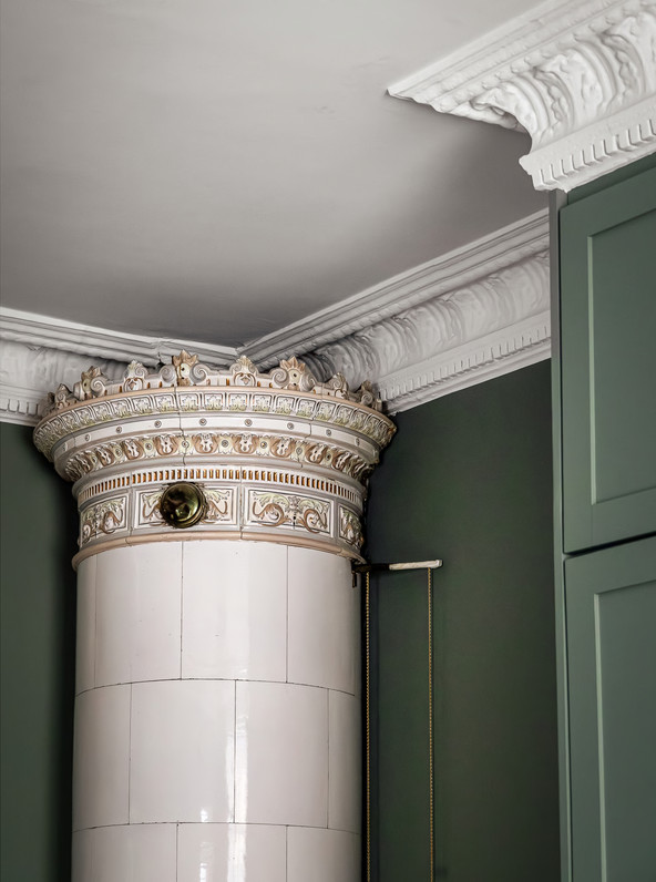 chambre vert sauge avec moulures stucs rosaces et poêle ancien appartement décoration scandinave