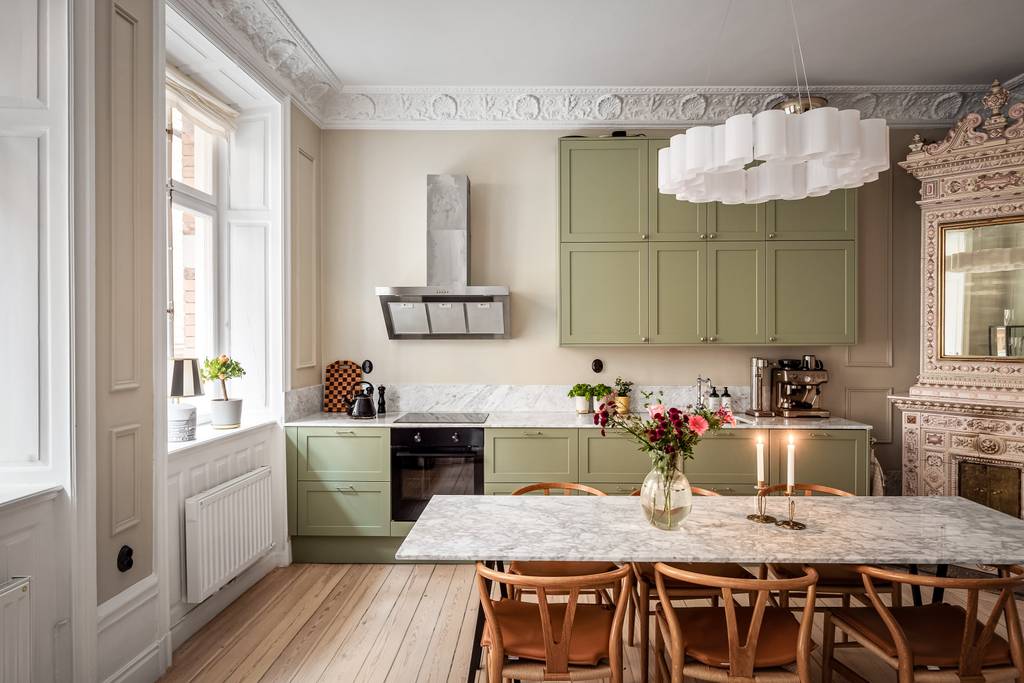 cuisine vert sauge avec moulures stucs rosaces et poêle ancien appartement décoration scandinave