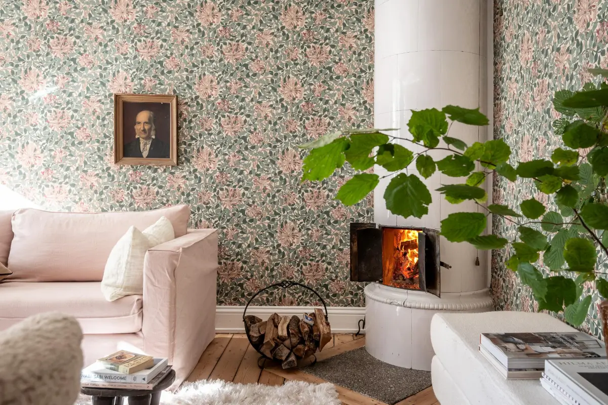 salon canapé rose pâle papier-peint William Morris vert et rose poêle ancien en céramique décoration scandinave