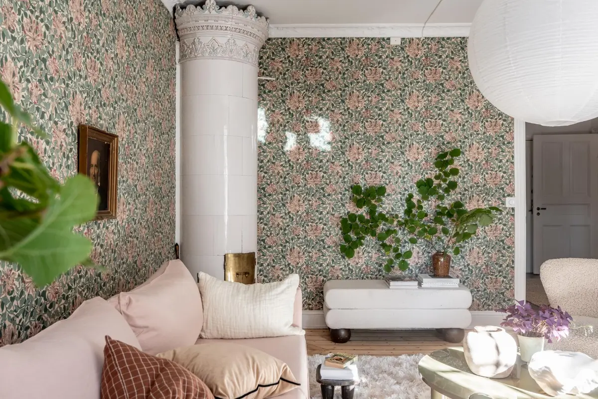 salon canapé rose pâle papier-peint William Morris vert et rose poêle ancien en céramique décoration scandinave