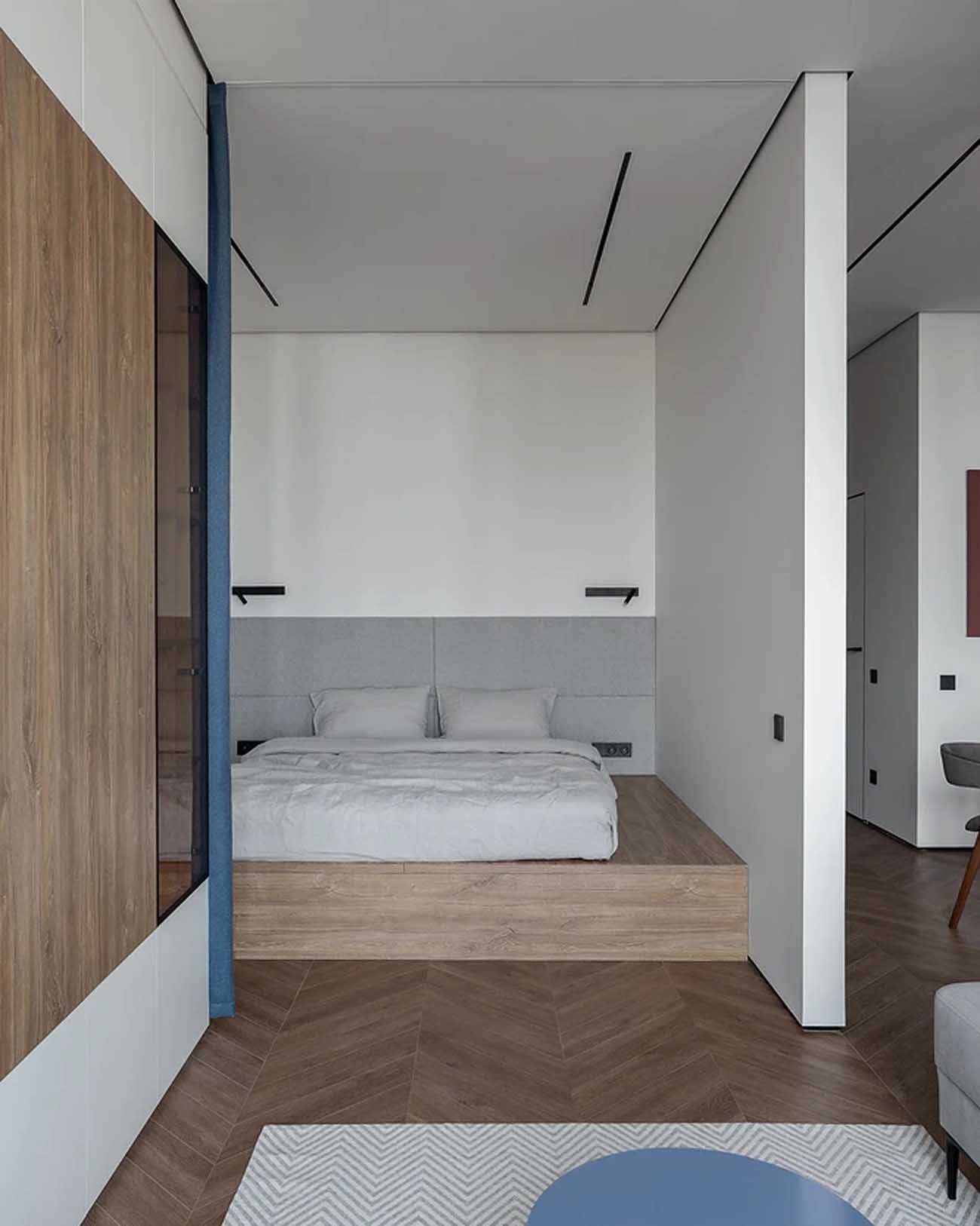 espace chambre sur estrade fermé par un rideau grand studio 47m2 avec dressing décoration contemporaine