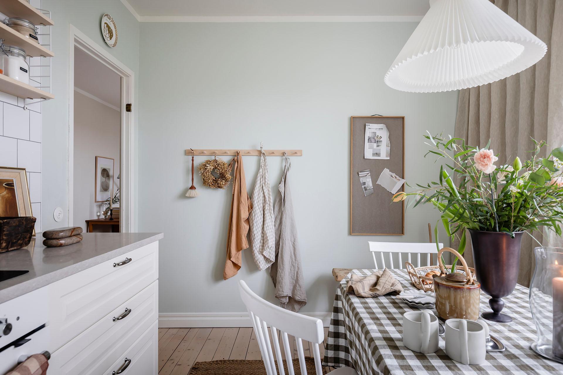 cuisine avec espace repas décoration scandinave et naturelle murs vert pâle appartement ancien de 60m2