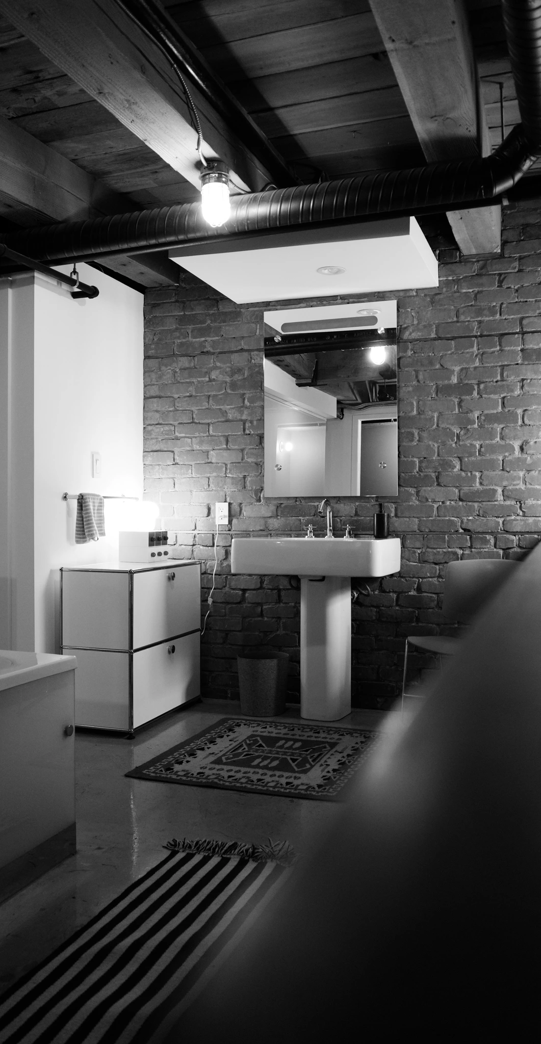 salle de bain sol béton appartement ancien à Vancouver type loft avec mur de briques anciennes décoration vintage