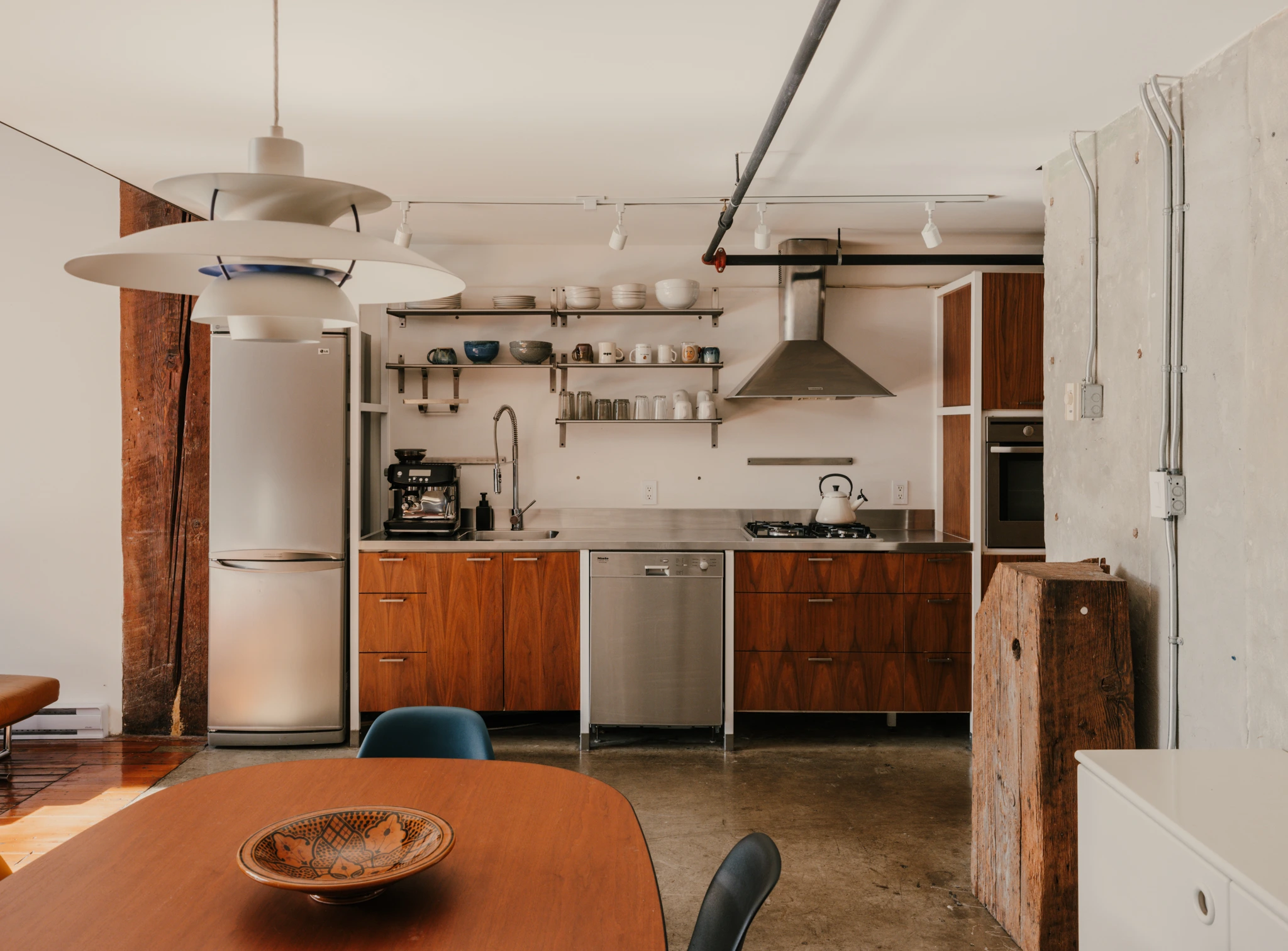 cuisine et salle à manger sol béton appartement ancien à Vancouver type loft avec poutre décoration vintage