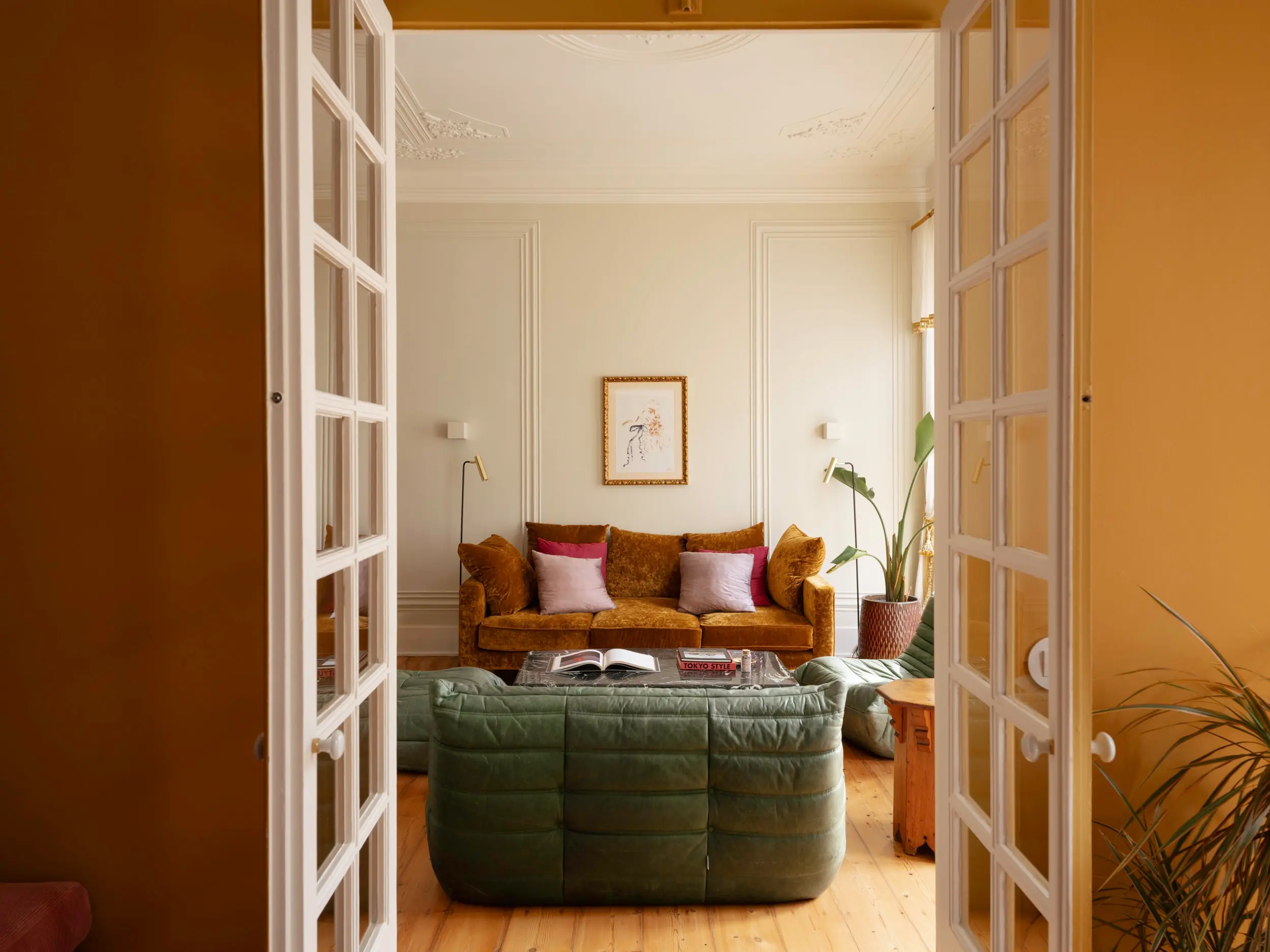 living room with green leather Togo sofa vintage apartment in Lisbon with refreshing garden living room with green leather Togo sofa vintage apartment in Lisbon with refreshing garden