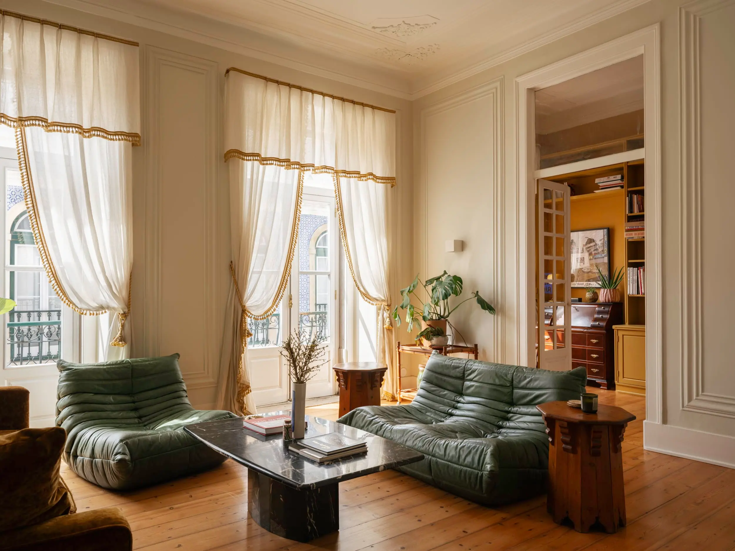 living room with green leather Togo sofa vintage apartment in Lisbon with refreshing garden living room with green leather Togo sofa vintage apartment in Lisbon with refreshing garden