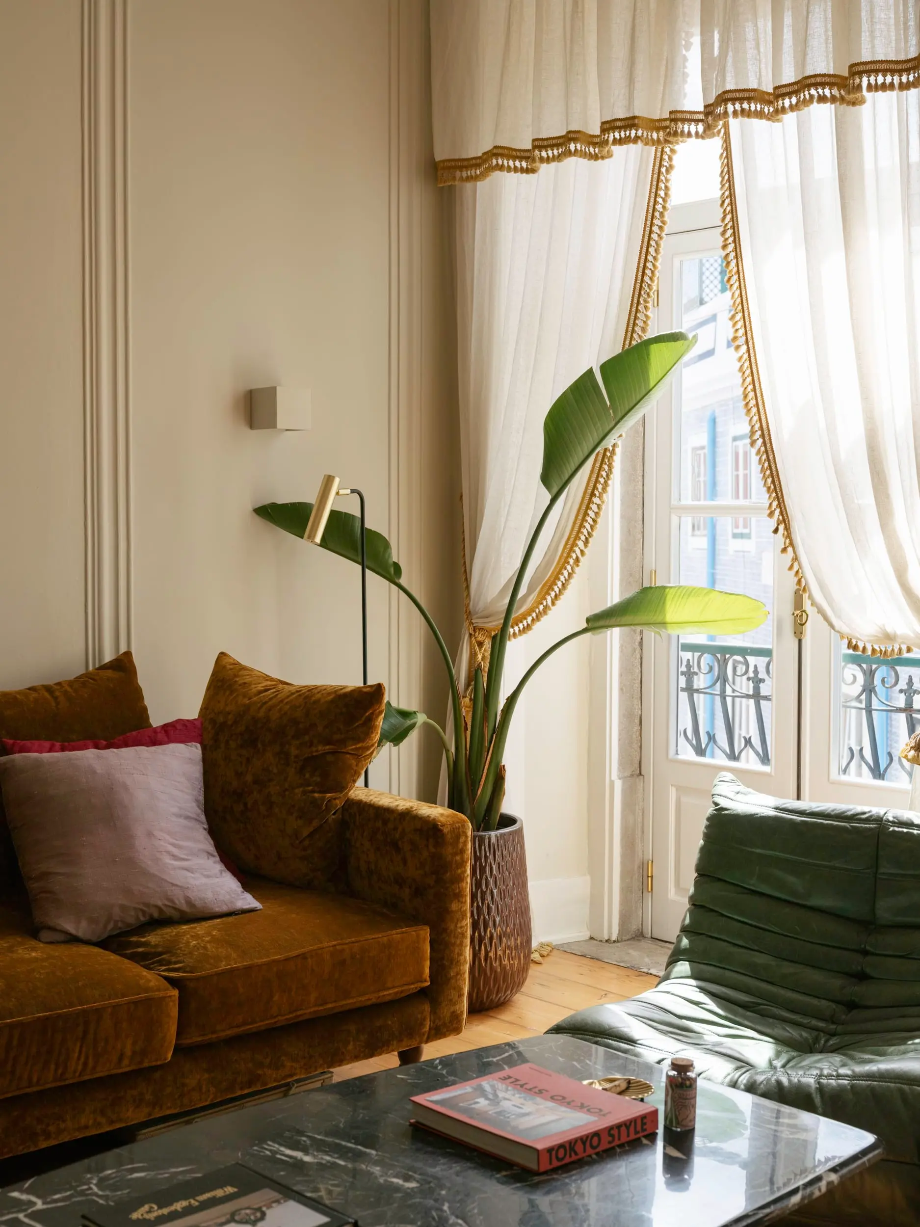 living room with green leather Togo sofa vintage apartment in Lisbon with refreshing garden living room with green leather Togo sofa vintage apartment in Lisbon with refreshing garden