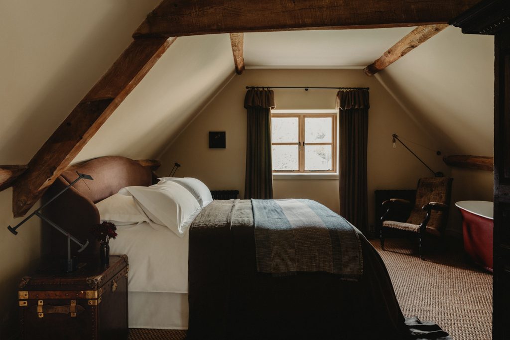 chambre mansardée avec poutres décoration classique chic maison dans ancienne grange anglaise rénovée