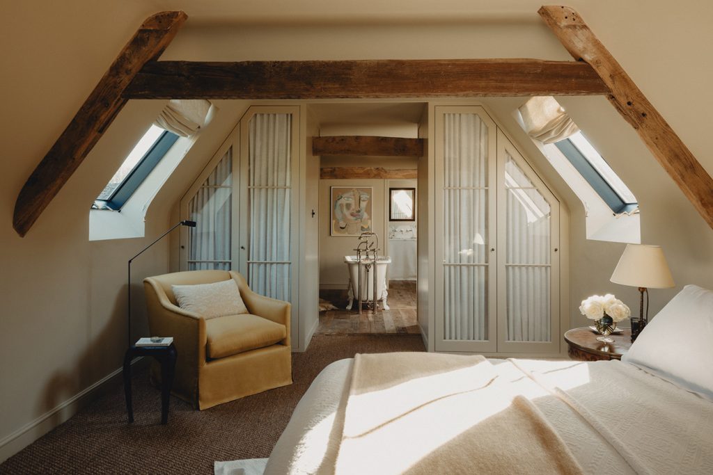 chambre mansardée avec poutres et salle de bain décoration classique chic maison dans ancienne grange anglaise rénovée