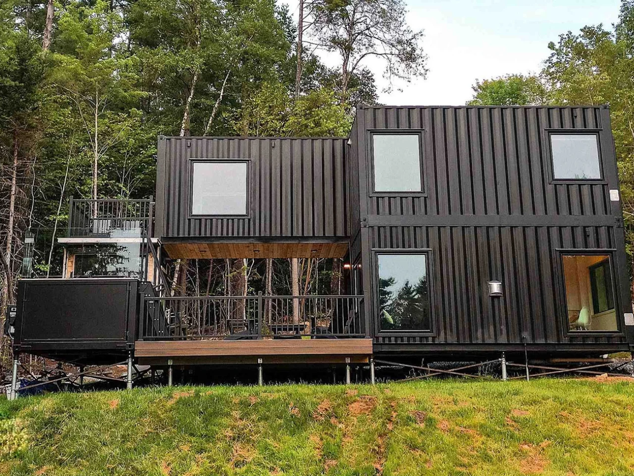Une vaste maison container avec piscine et sauna entourée par la nature