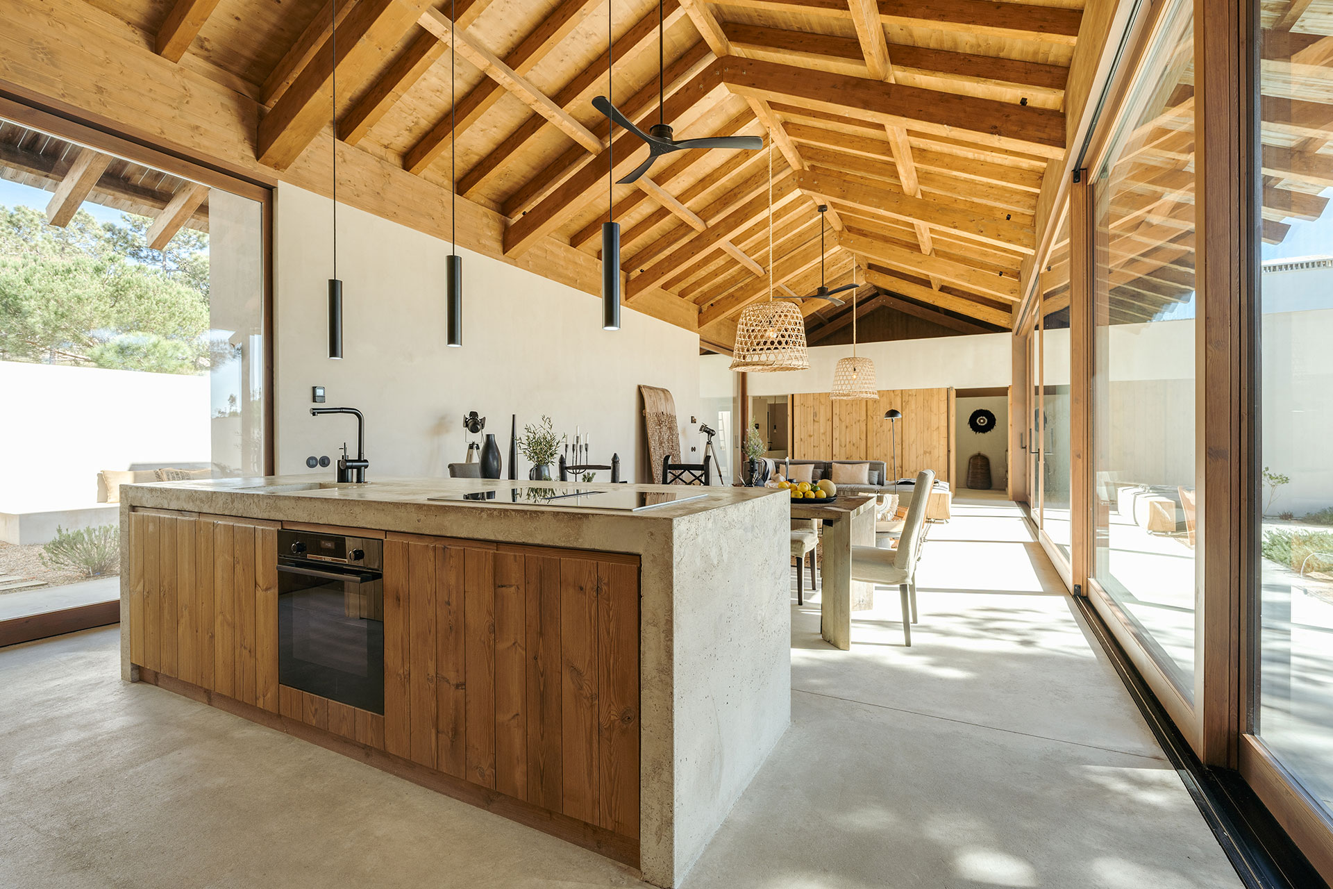 open kitchen with island and dining room with double height wooden ceiling natural style decor house in Comporta Villa Sandstone