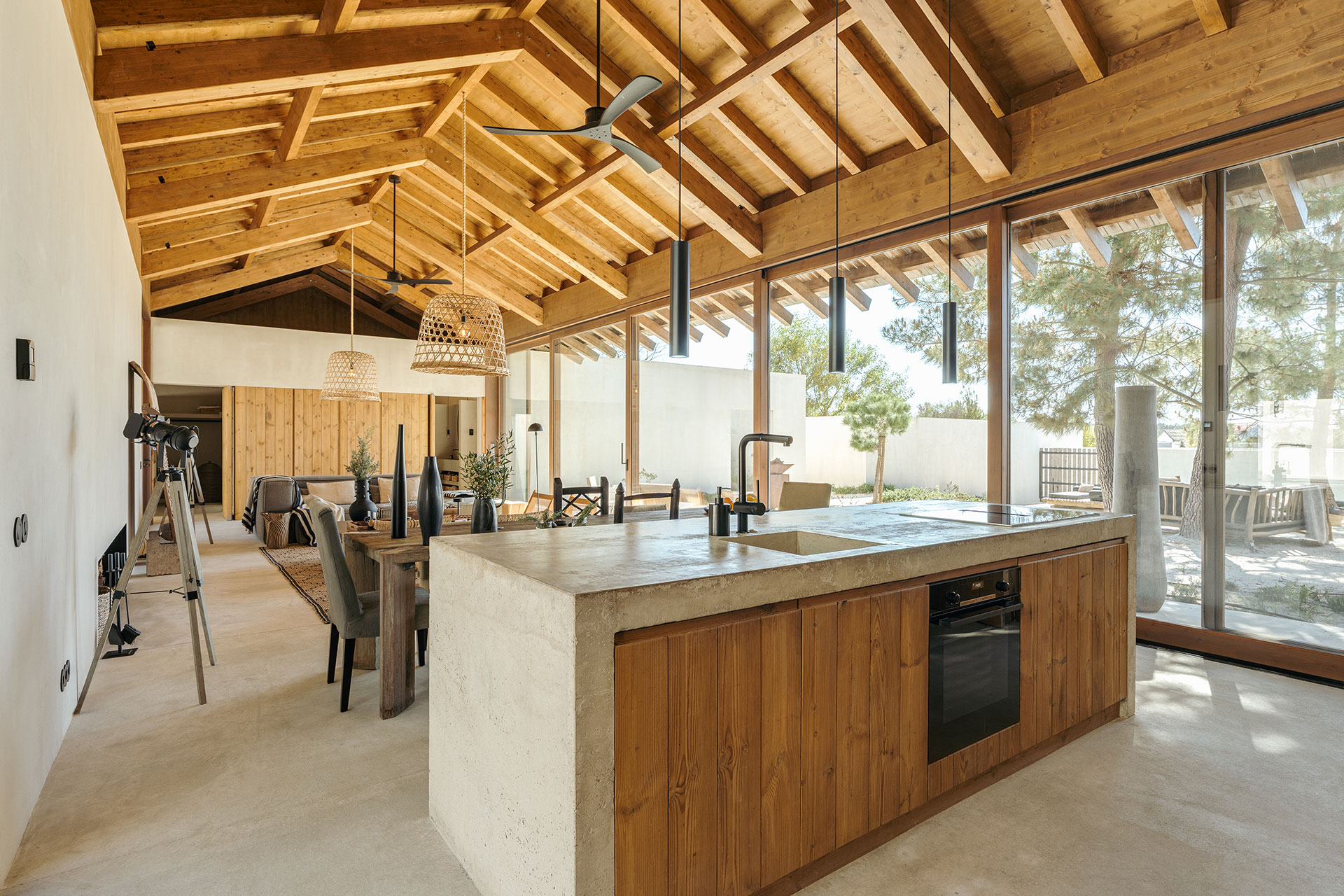 open kitchen with concrete island and living room with double height wooden ceiling natural style decor house in Comporta Villa Sandstone