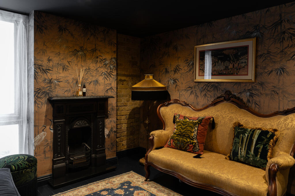 petit salon avec cheminée ancienne en fonte canapé rococo jaune décoration vintage appartement en duplex Londres