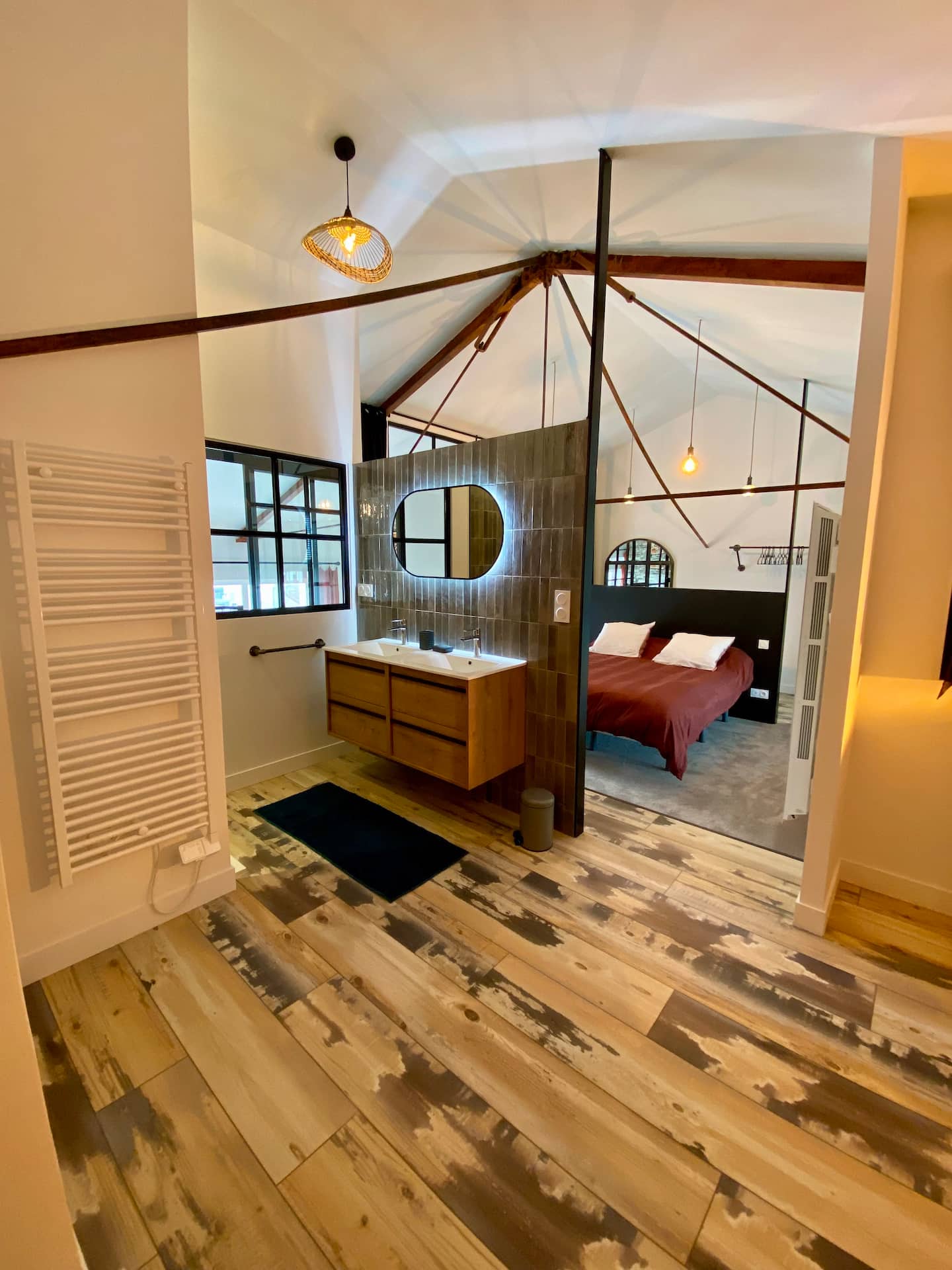 chambre sur mezzanine avec verrière et salle de bain décoration loft appartement en duplex Royan dans une ancienne école