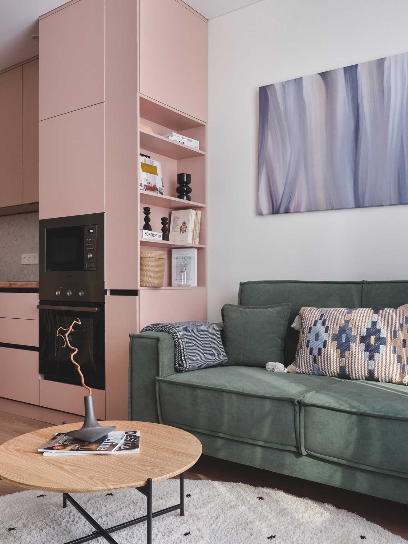 pink kitchen and living room with green sofa in a two-room 42sqm apartment pink kitchen and living room with green sofa in a two-room 42sqm apartment
