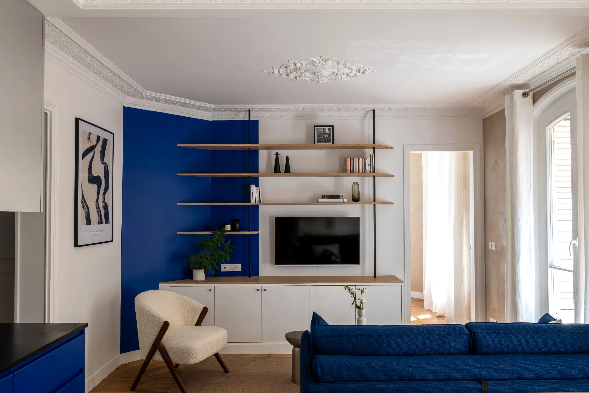 salon avec moulures et cuisine appartement haussmannien de 46m2 rénové en bleu Klein Photo : ©Agathe Tissier