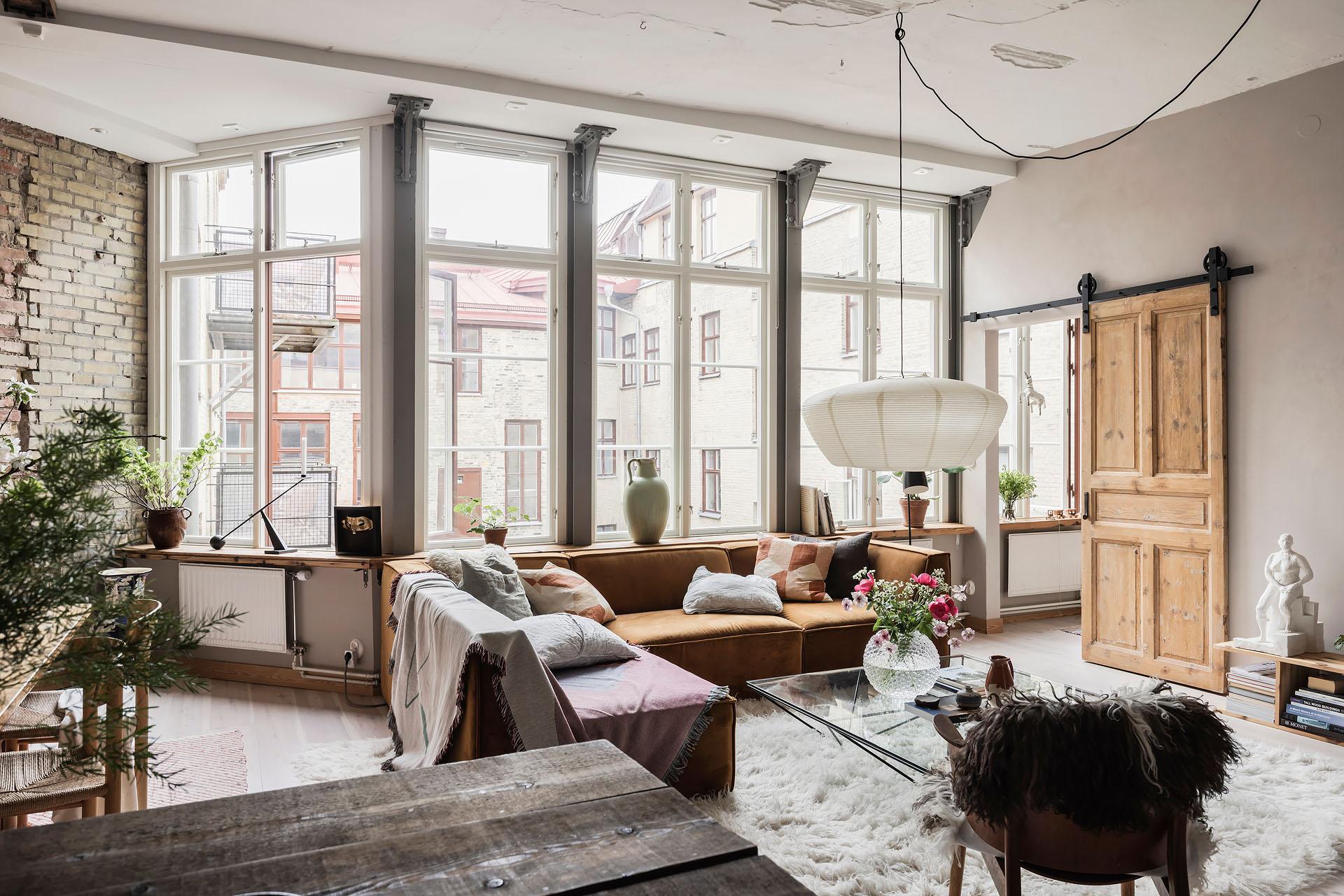 salon avec murs briques anciennes et poutres appartement 80m2 décoration scandinave