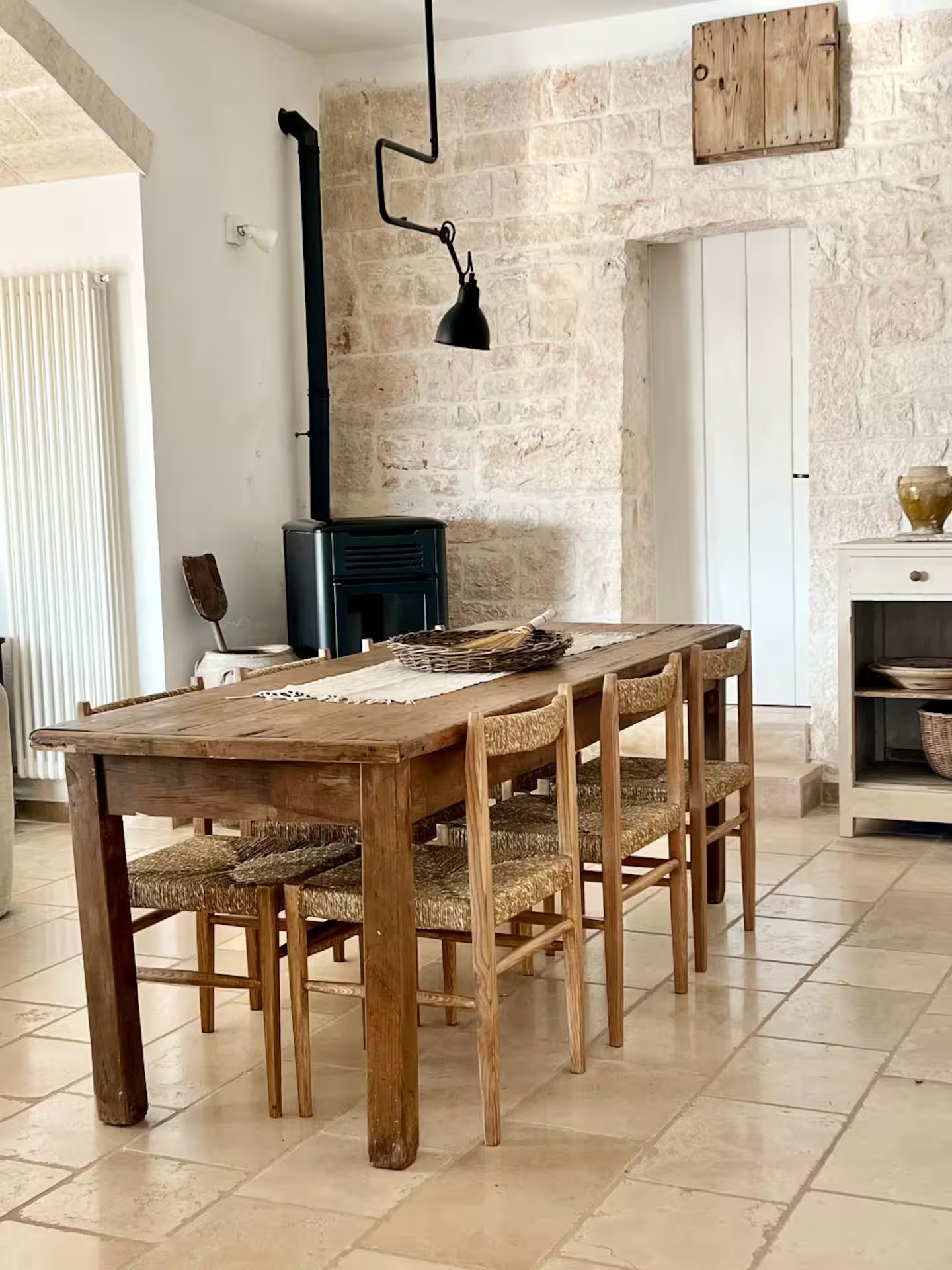 salle à manger avec poêle mur de pierre trullo des Pouilles rénové décoration rustique chic Trullo Falco