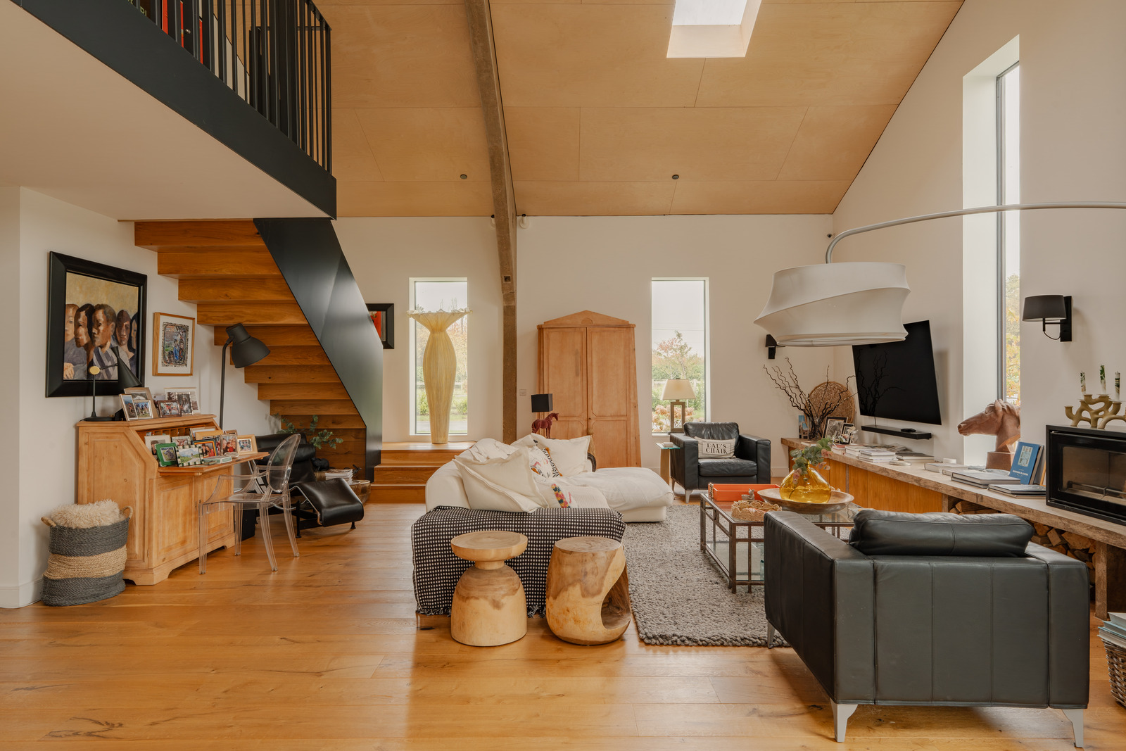 salon double hauteur avec un escalier décoration contemporaine maison écologique dans ancienne grange agricole Angleterre