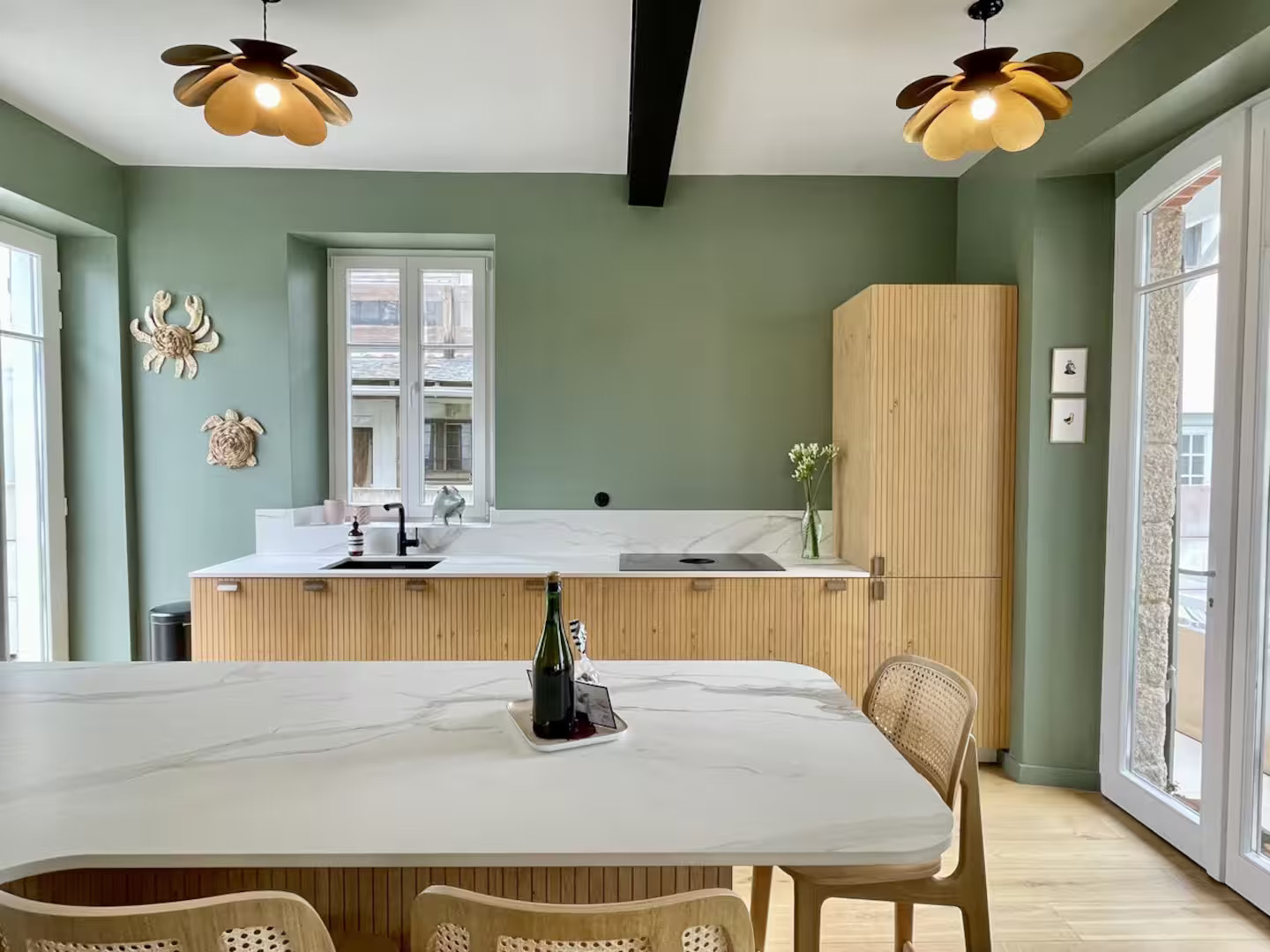 salle à manger et cuisine ouverte murs verts décoration contemporaine maison typique à Carnac Bretagne Les Oiselières