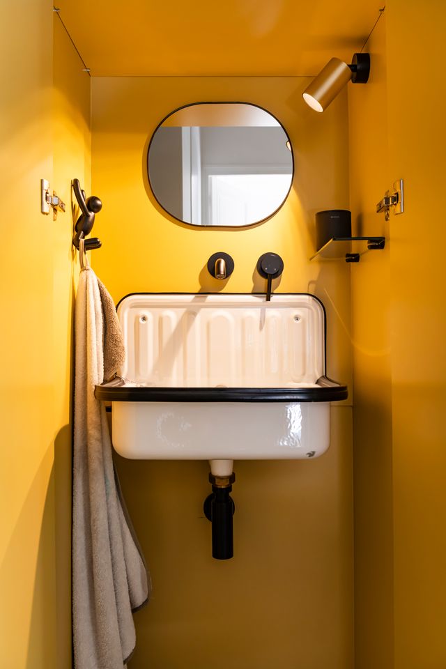 cabinet de toilette jaune caché dans placard appartement haussmannien de 107m2 Paris rénovation par d'Ussel & Decoster Photo : ©Julien Pepy