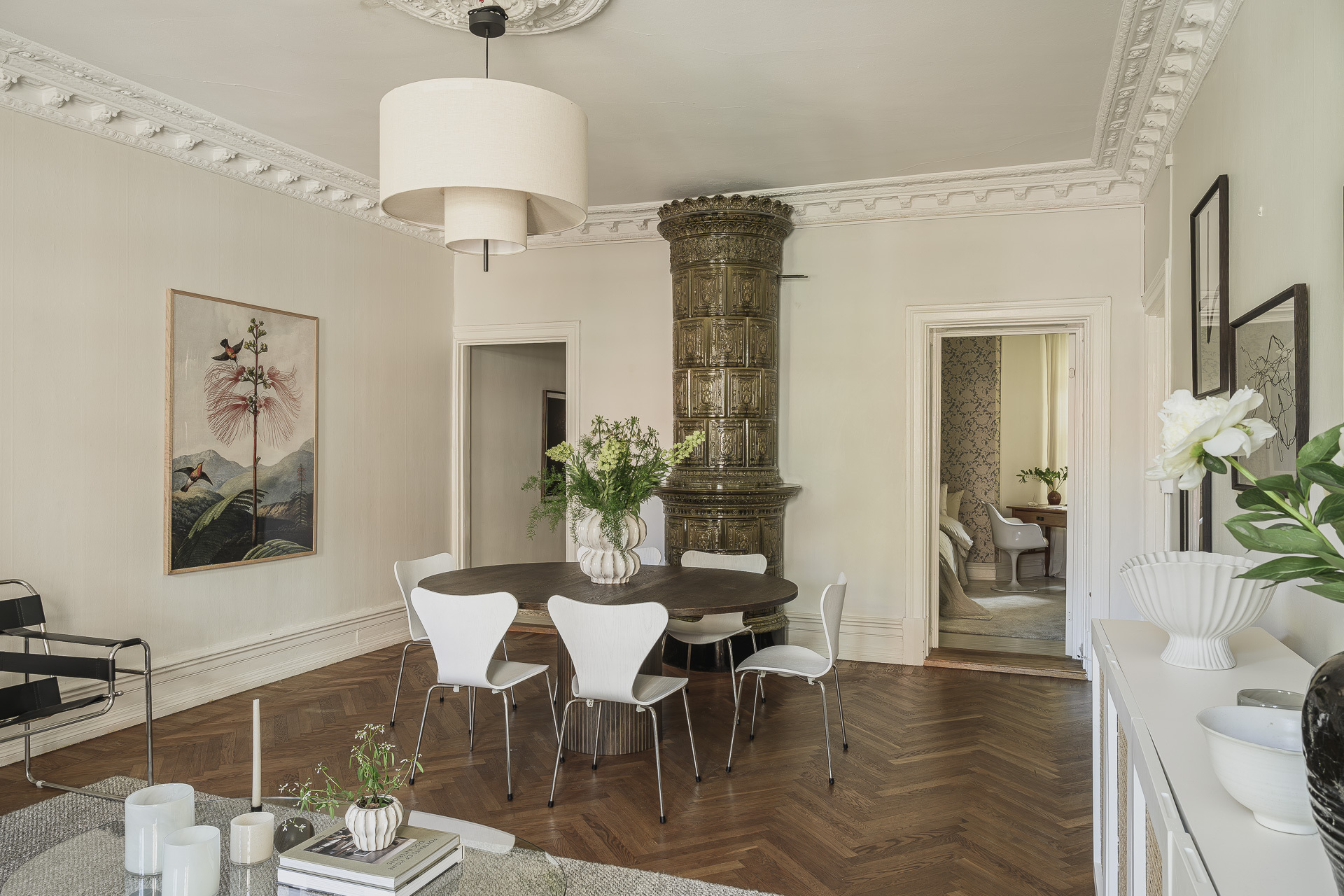 salle à manger et salon avec poêle ancien en céramique verte décoration scandinave beige avec moulures