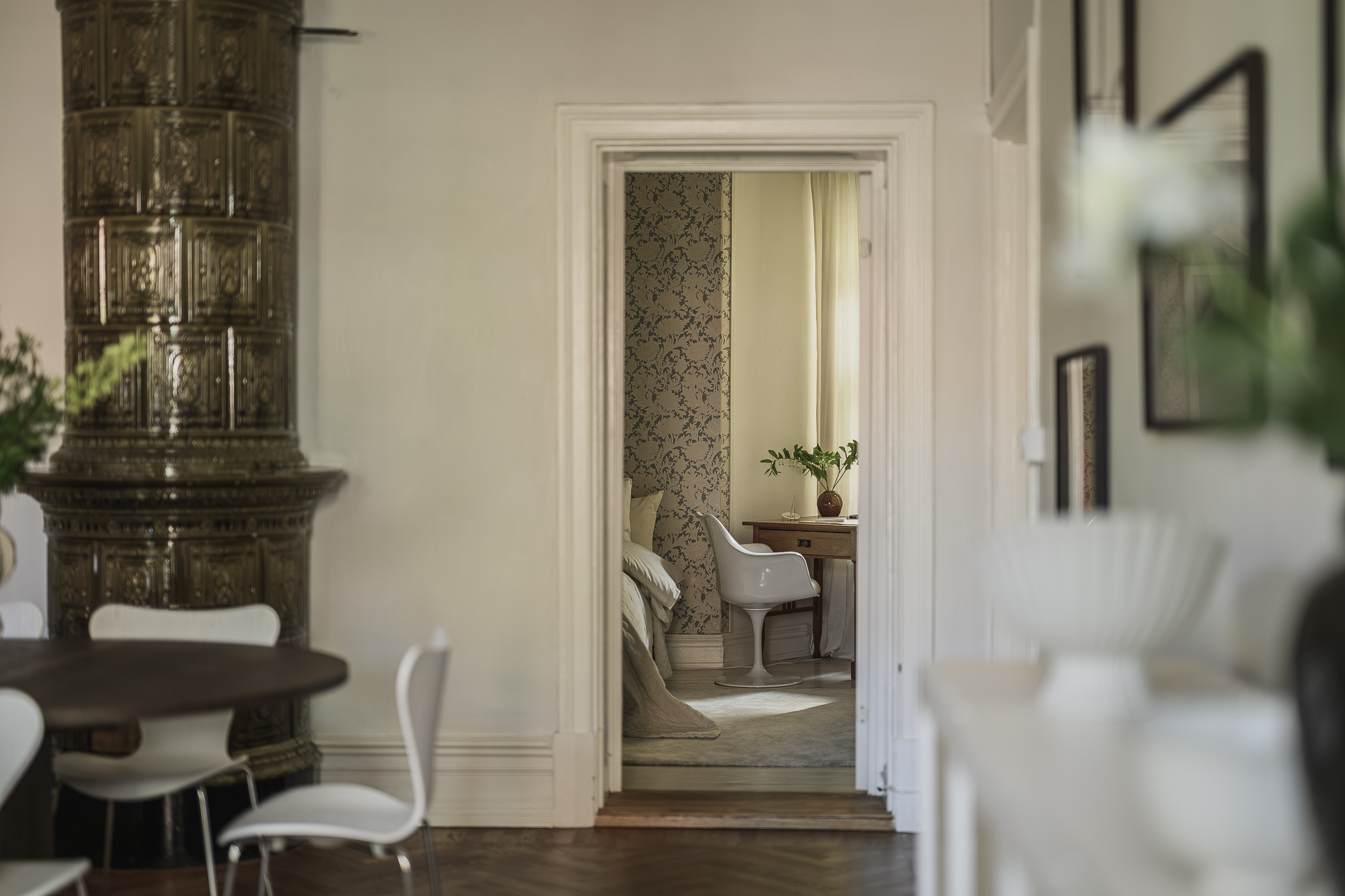 salle à manger avec poêle ancien en céramique verte décoration scandinave beige avec moulures