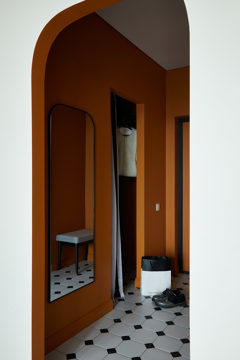 entrée avec ouverture cintrée murs terracotta sol blanc cabochons noirs décoration contemporaine studio 36m2