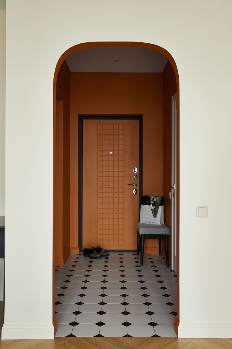entrée avec ouverture cintrée murs terracotta sol blanc cabochons noirs décoration contemporaine studio 36m2