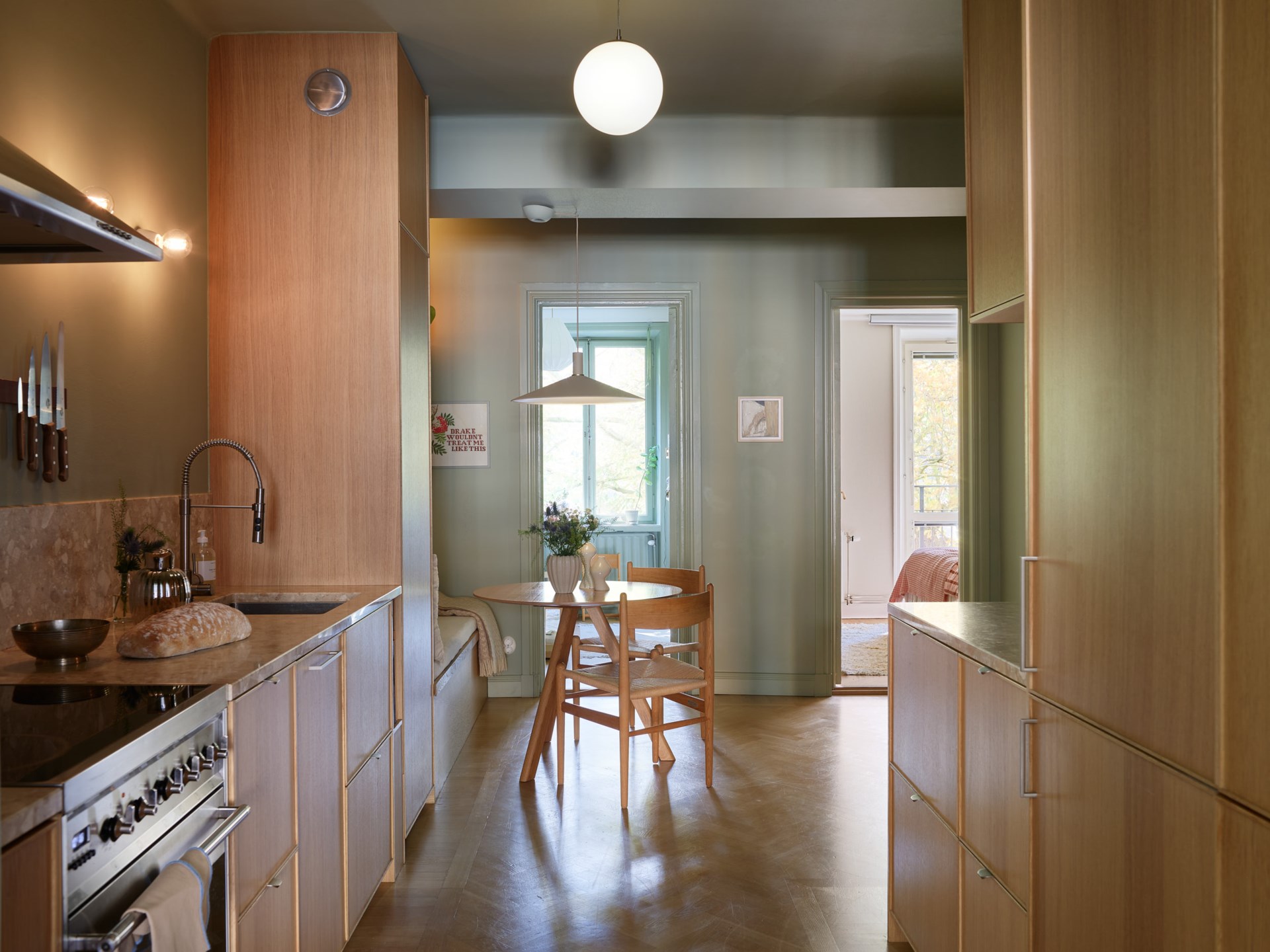 cuisine chêne murs verts avec espace repas sur mesure appartement trois-pièces 66m2 décoration scandinave