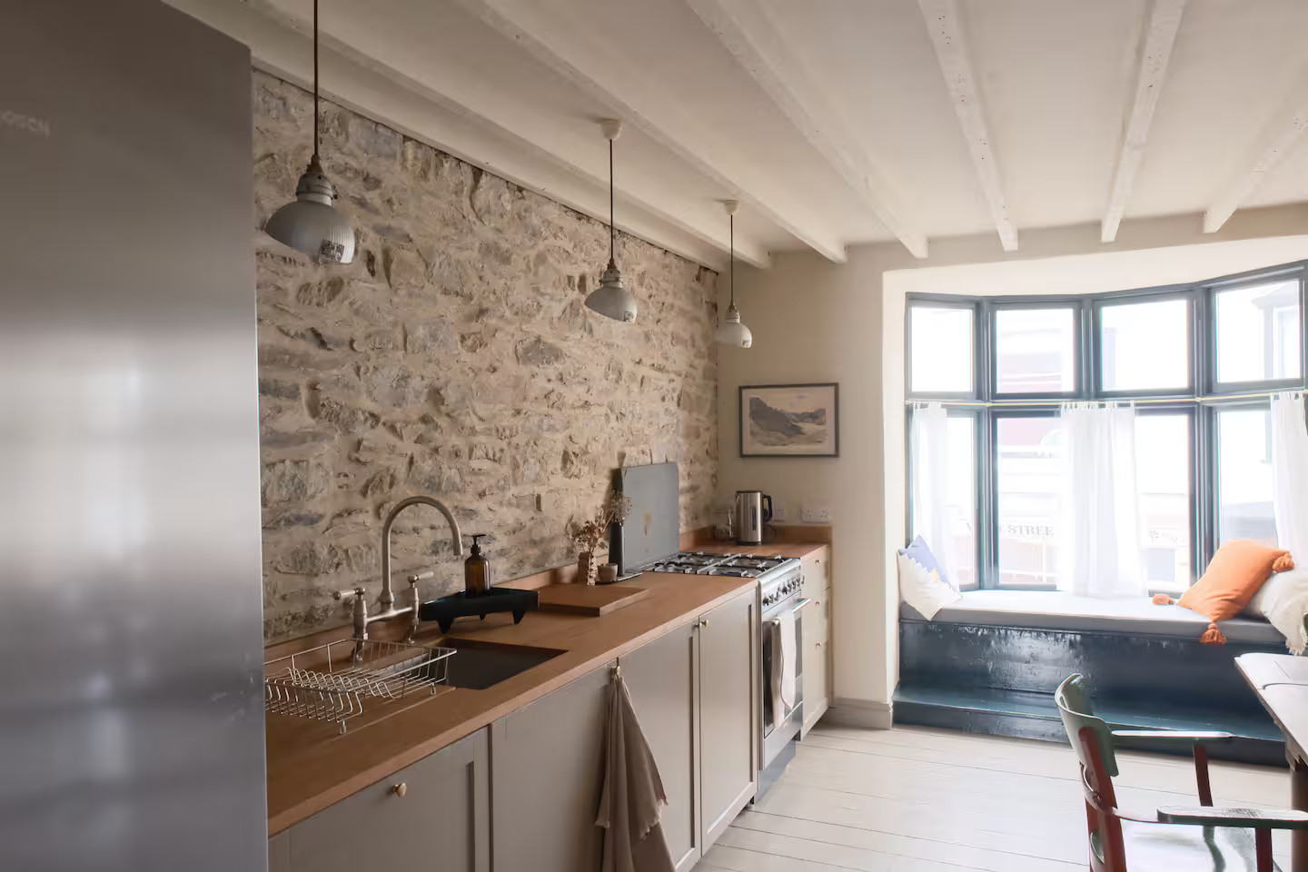 cuisine avec mur de pierre et banquette sous la fenêtre maison Pays de Galles Ty Clai