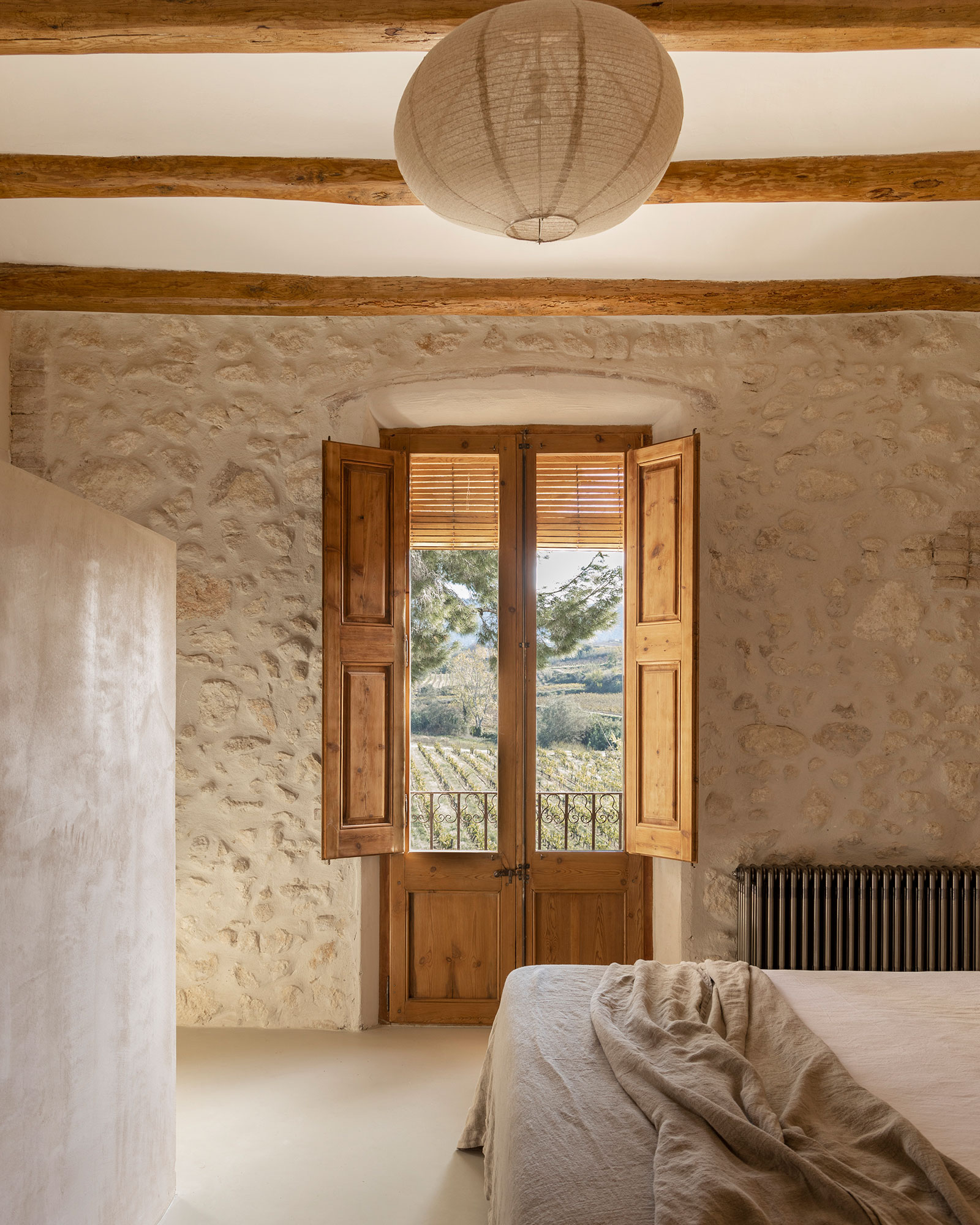 chambre mur de pierres et poutres décoration rustique chic et naturelle ferme du 18e siècle rénovée Mas Grimosach