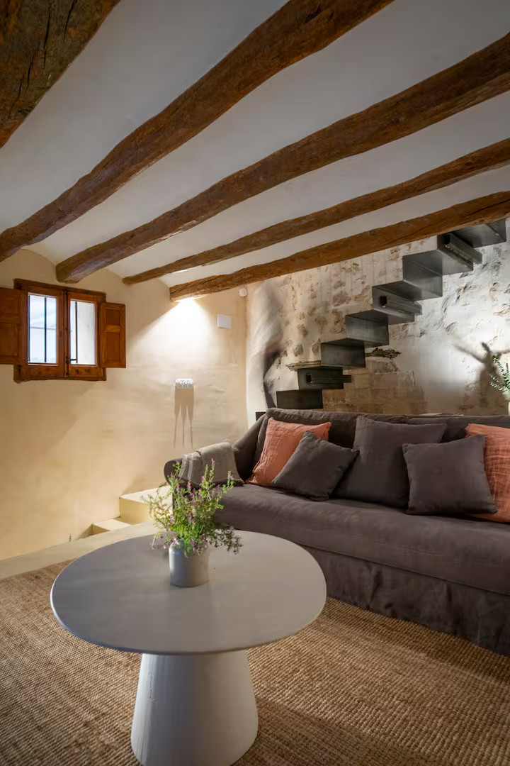 salon avec mur en pierres et poutres décoration rustique chic et naturelle ferme du 18e siècle rénovée Mas Grimosach
