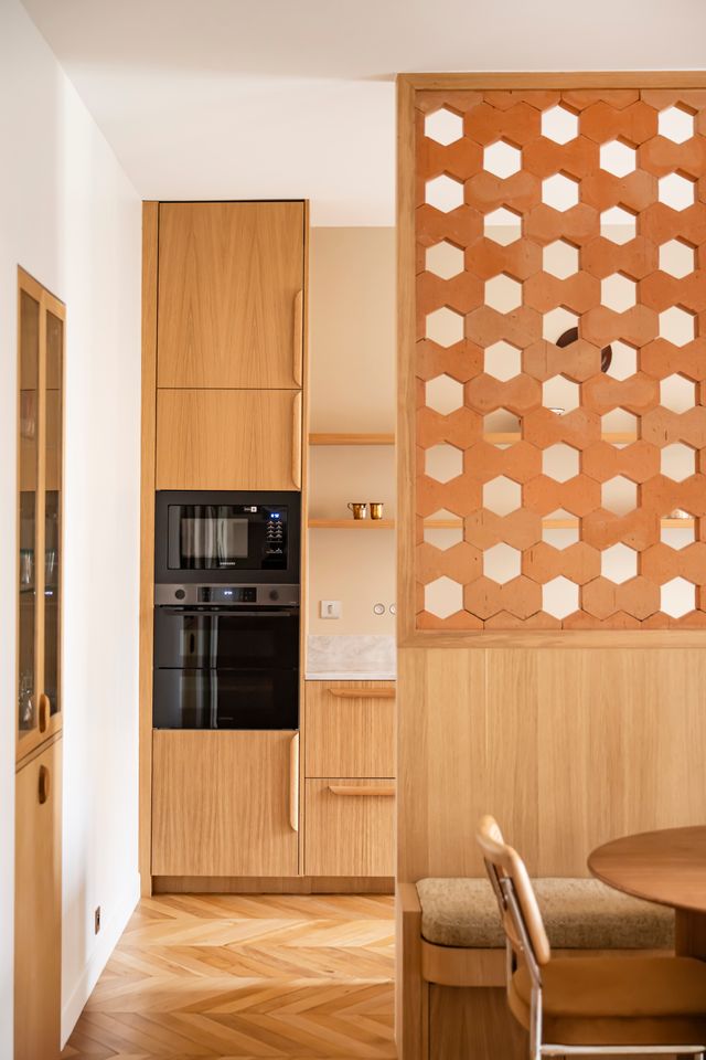 cuisine et salle à manger avec claustra Hives Mutina et moulures décoration contemporaine appartement haussmannien rénové Paris Photo : © Julien Pépy