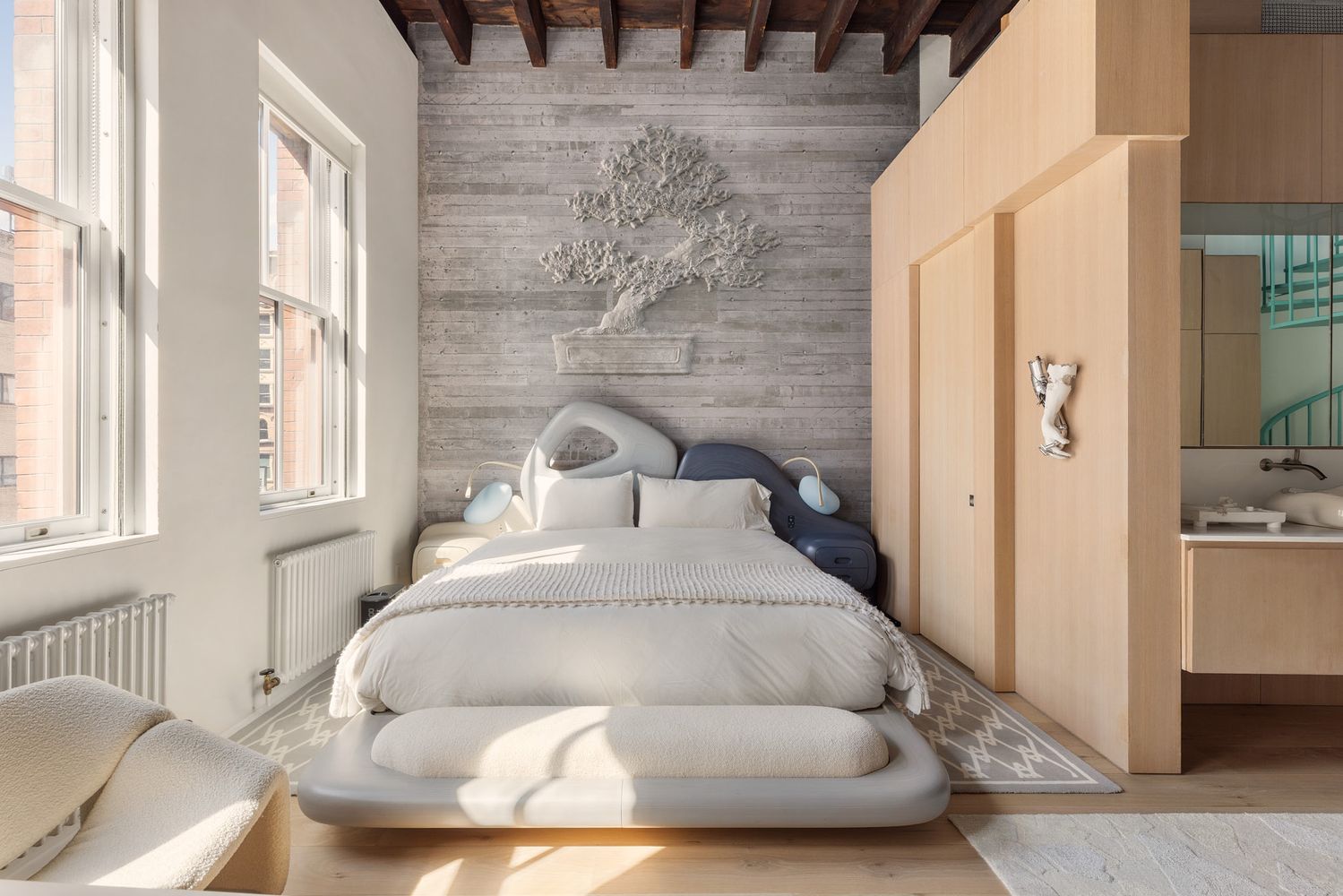 chambre avec poutres murs béton et salle de bain ouverte décoration design dans ancienne caserne de pompiers SoHo New York maison de Daniel Arsham