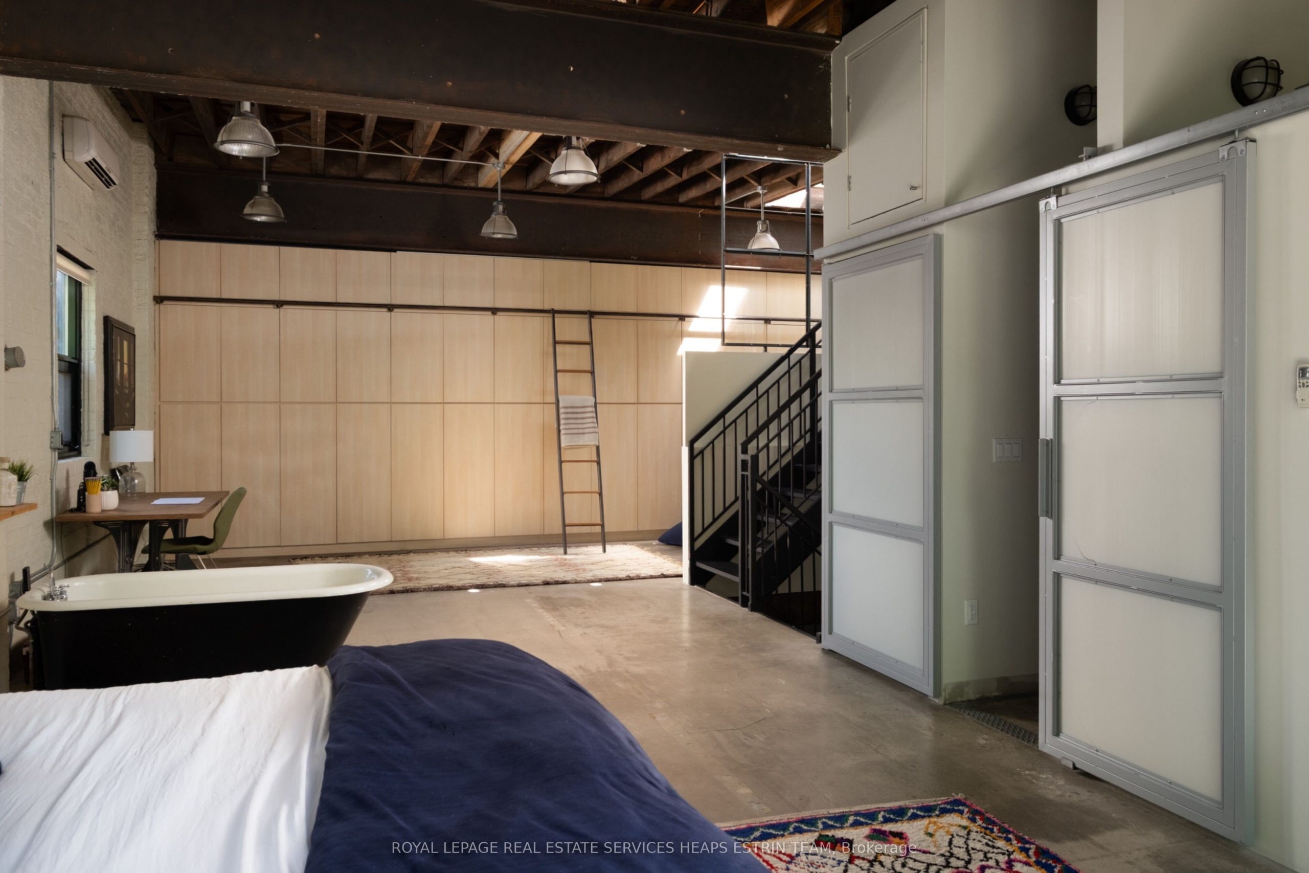 chambre avec baignoire avec poutres sol béton murs de briques blanches loft authentique et ancien dans un ancien garage à Toronto chambre avec baignoire avec poutres sol béton murs de briques blanches loft authentique et ancien dans un ancien garage à Toronto