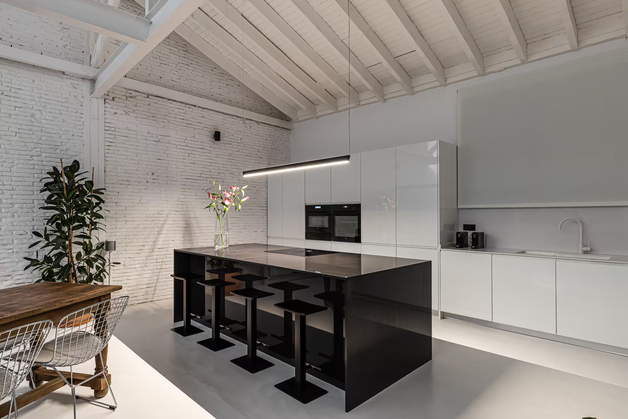salle à manger et cuisine ouverte murs briques blanches poutres métalliques appartement industriel de 175m2 de style loft décoration contemporaine