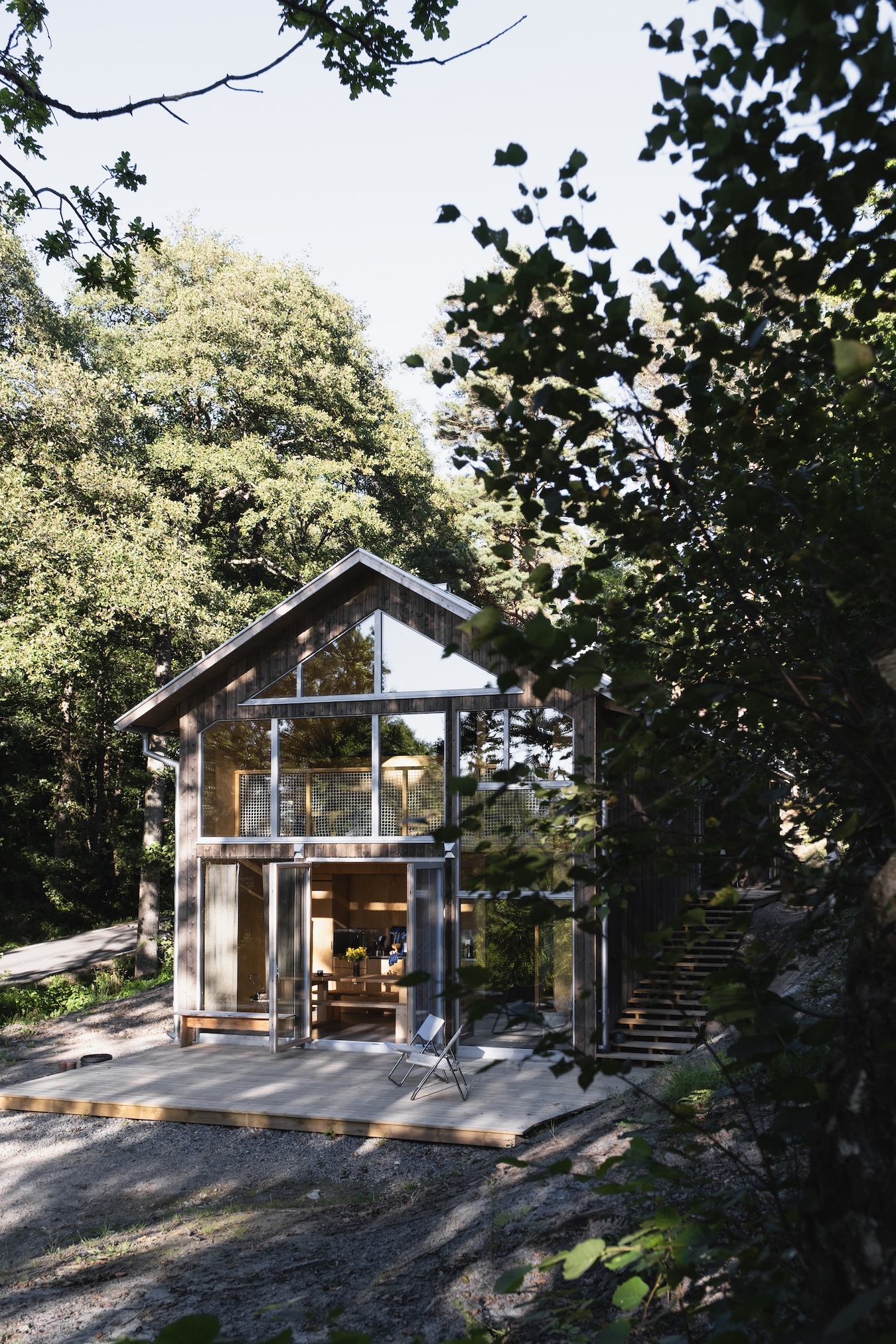maison en bois avec pignon vitré entourée d'arbres