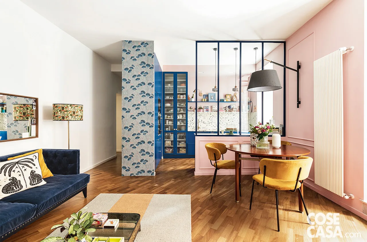 pink living room with blue sofa and semi glazed partition
