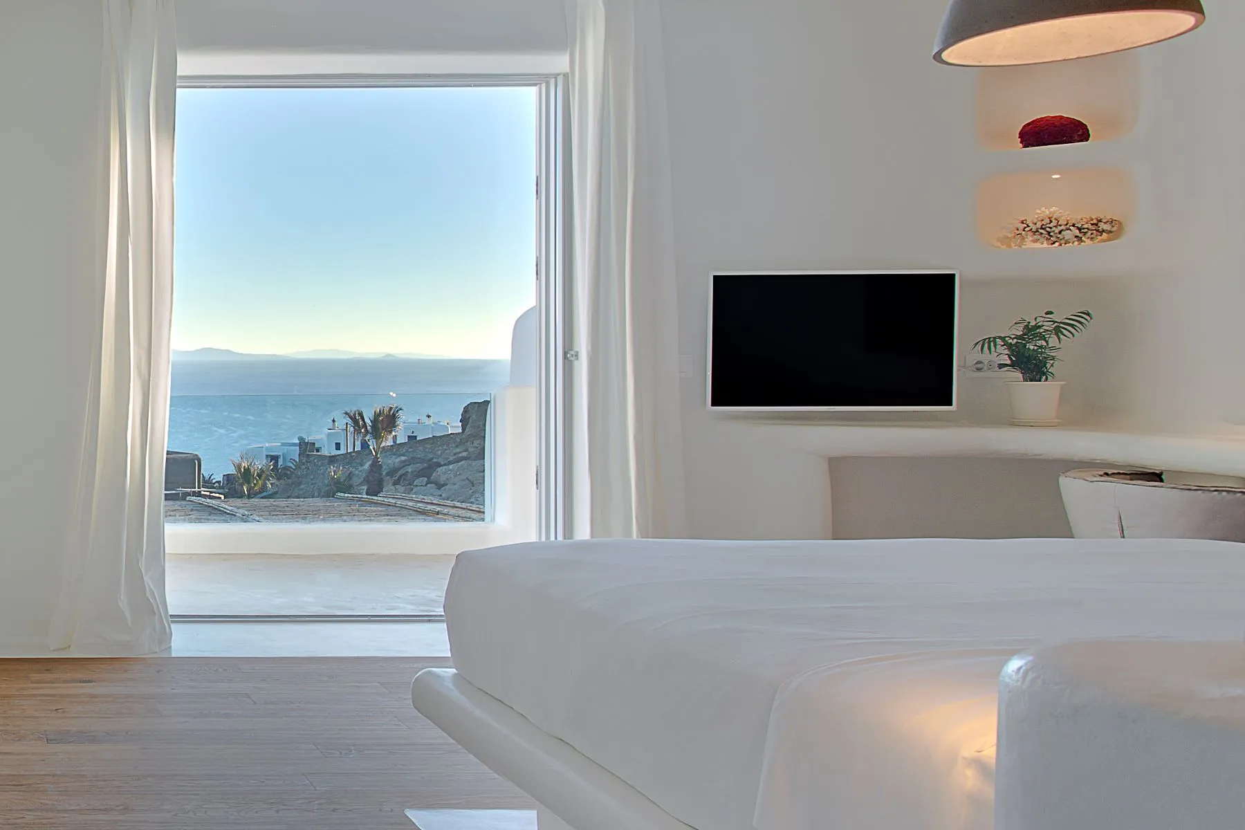 chambre blanche vue mer décoration contemporaine mur de pierres maison design à Mykonos avec piscine chambre blanche vue mer décoration contemporaine mur de pierres maison design à Mykonos avec piscine