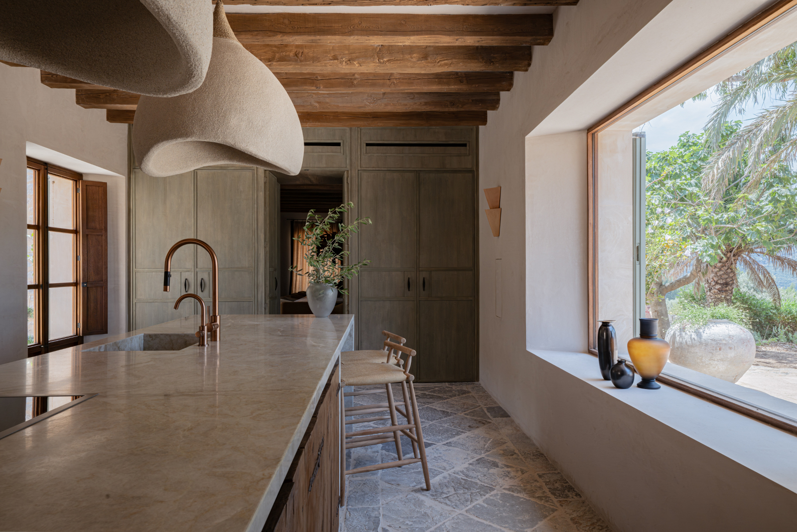 cuisine contemporaine avec poutres et picture window finca rénovée à Majorque maison en pierre Son Verí cuisine contemporaine avec poutres et picture window finca rénovée à Majorque maison en pierre Son Verí