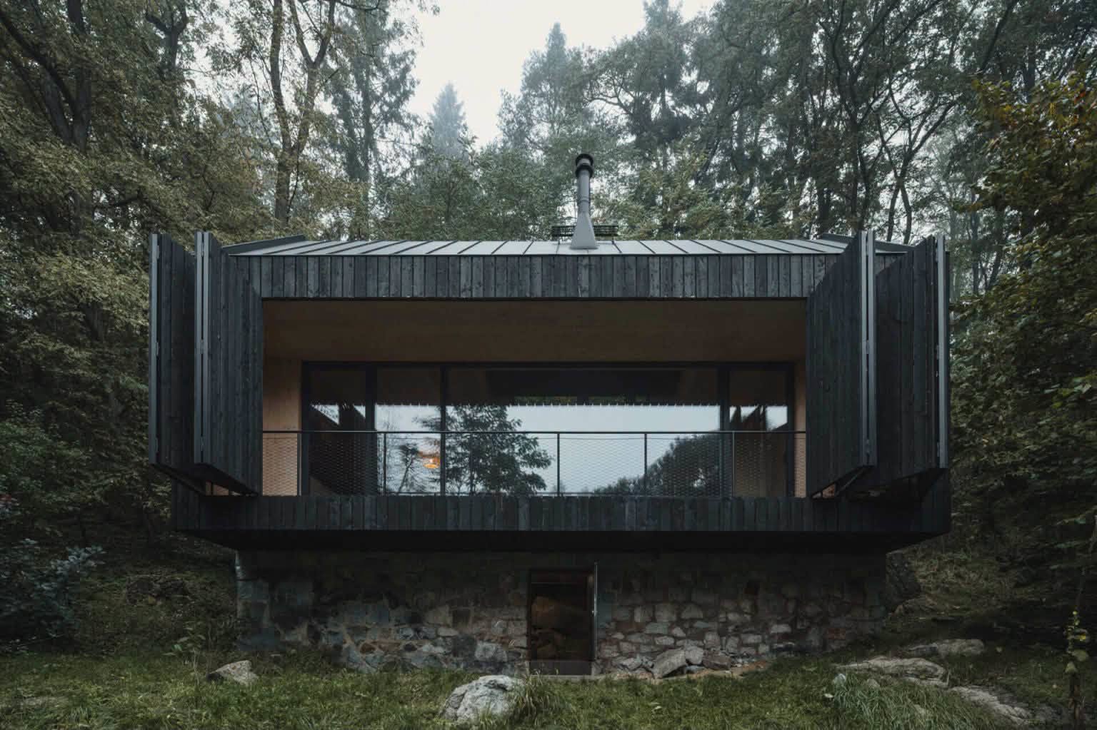 maison noire en bois contemporaine entourée d'arbres